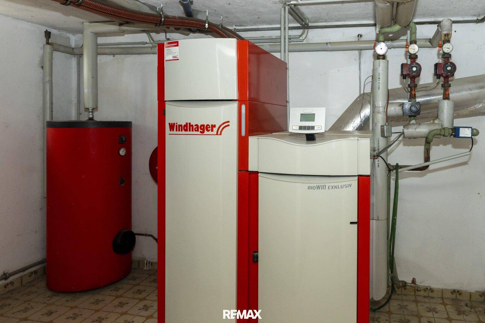 Heizungsraum mit moderner Biomasse-Heizanlage und Warmwasserspeicher.