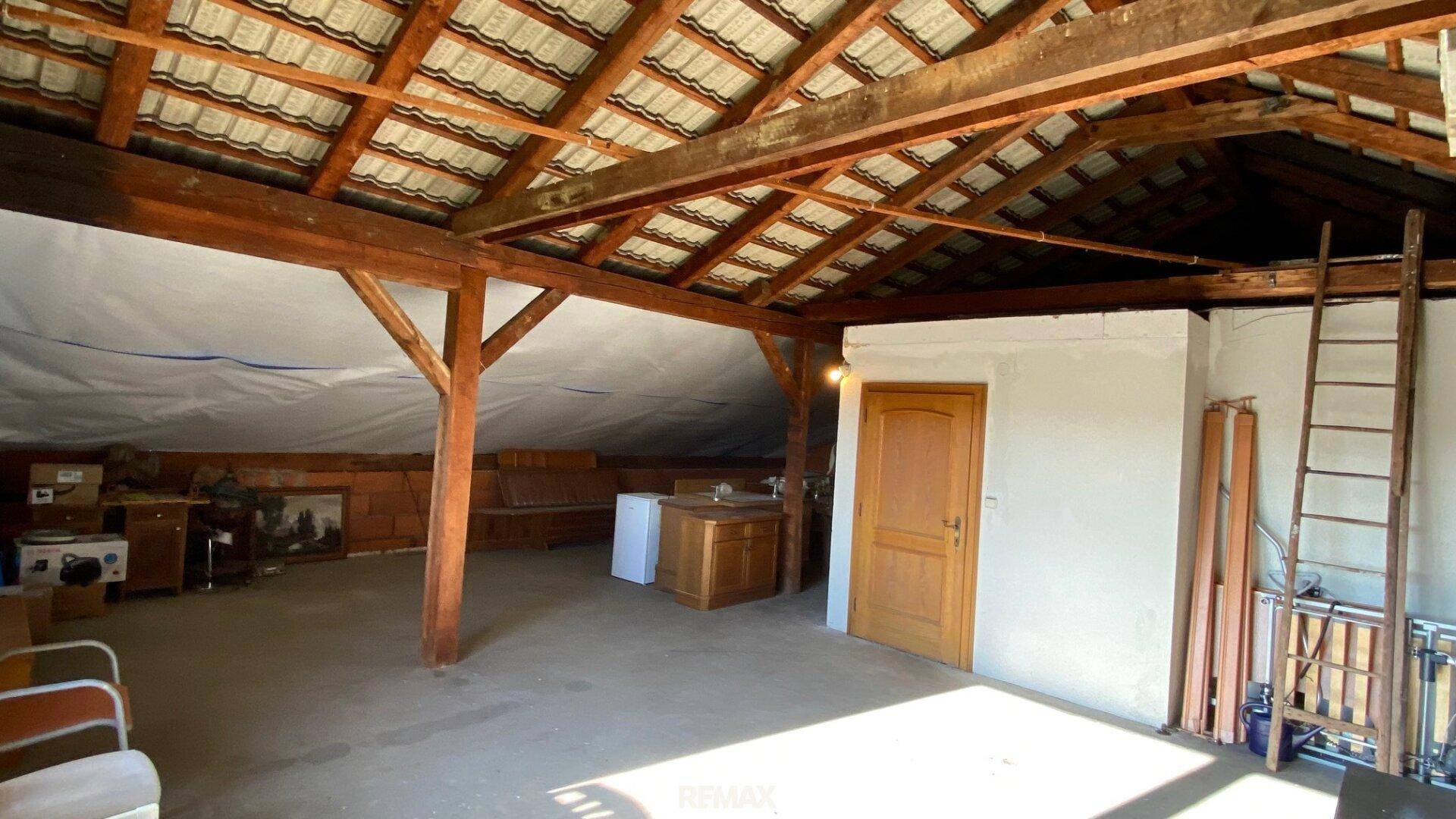 Geräumiger Dachboden mit sichtbaren Holzbalken und viel Stauraum.