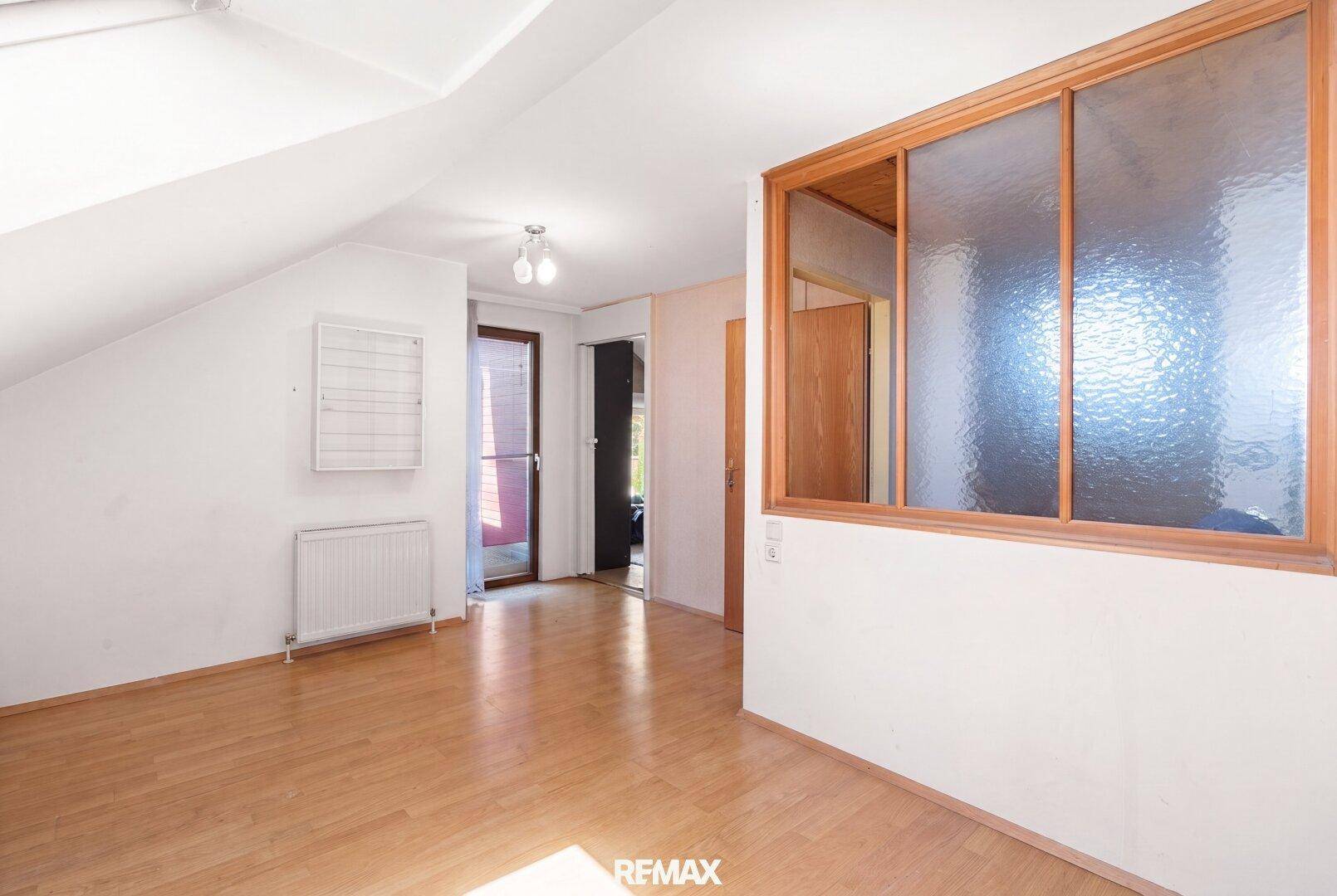 Heller Dachgeschossraum mit schräger Decke und Holzboden, ideal als zusätzlicher Wohnraum nutzbar.