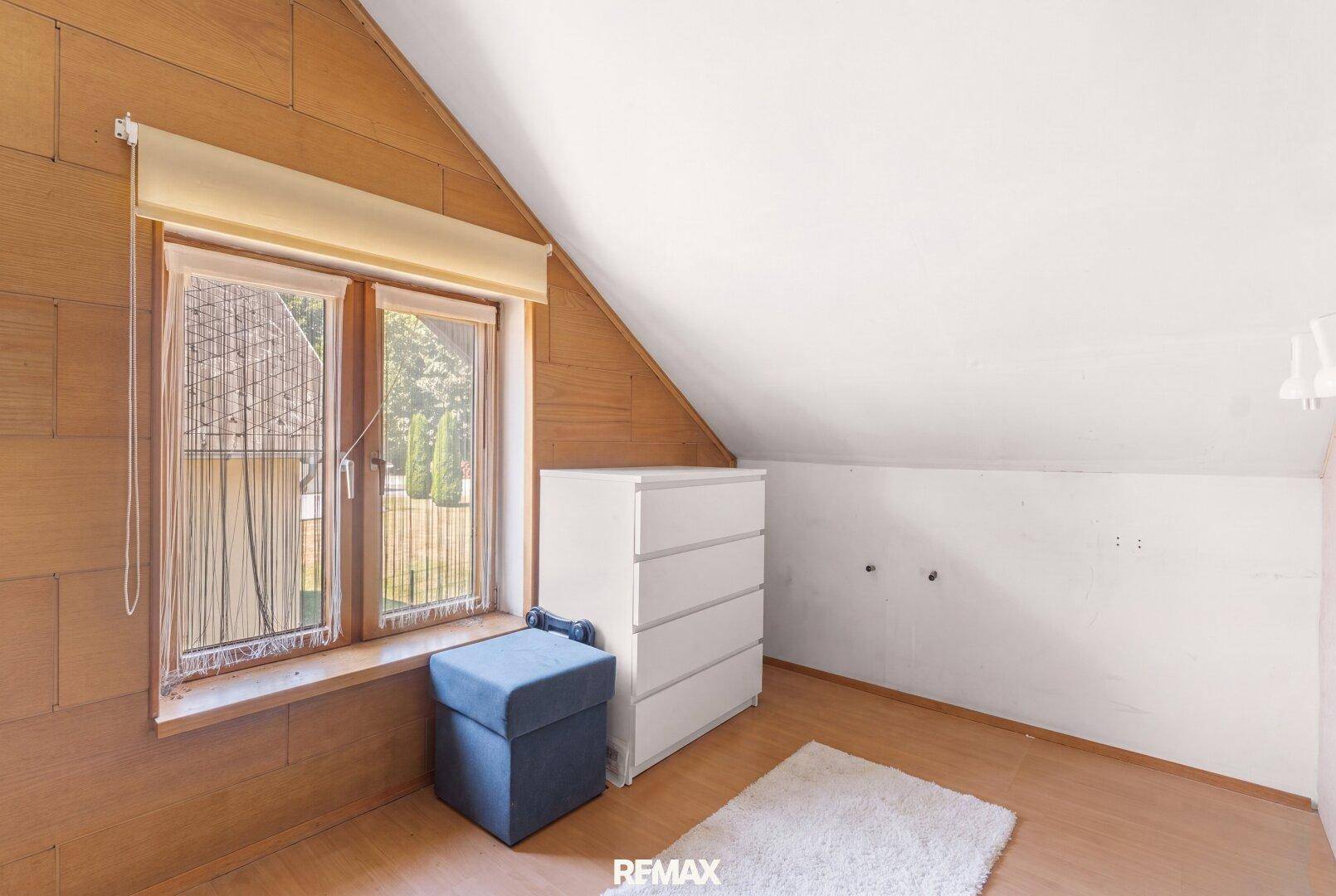 Dachgeschosszimmer mit schräger Decke und Holzboden, bereit zur individuellen Gestaltung und Nutzung.