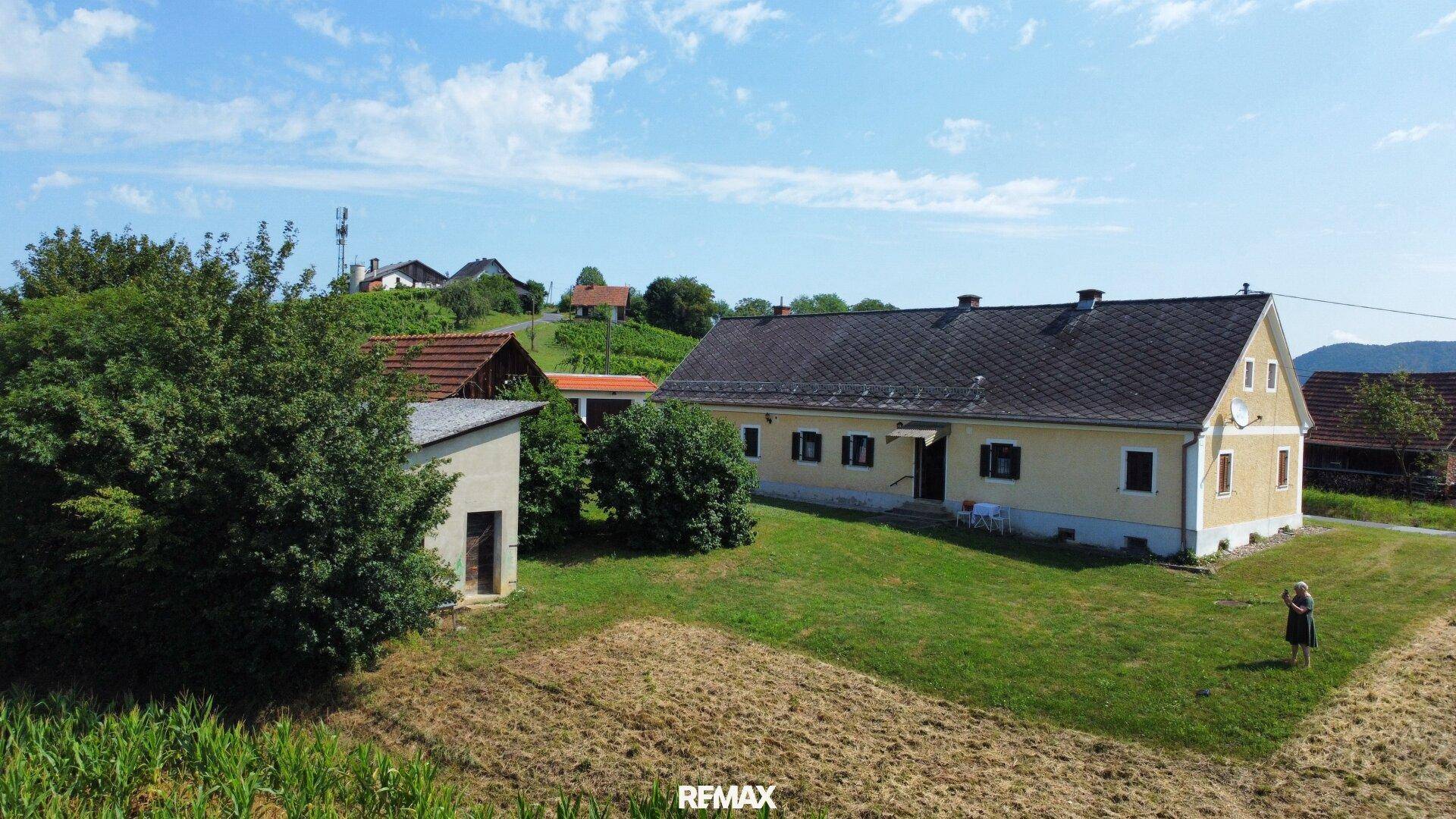 Luftaufnahme des Hauptgebäudes eines ländlichen Anwesens mit großem Garten und angrenzenden Feldern.
