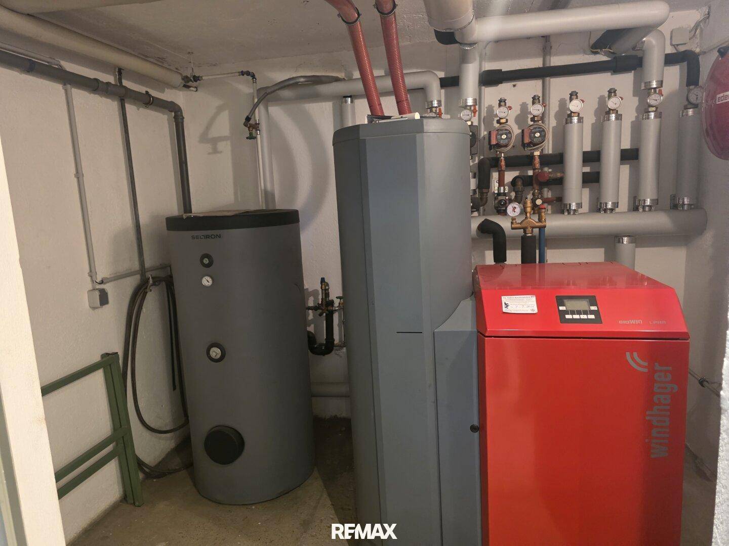 Heizungsraum mit moderner Wärmepumpe und Warmwasserspeicher.