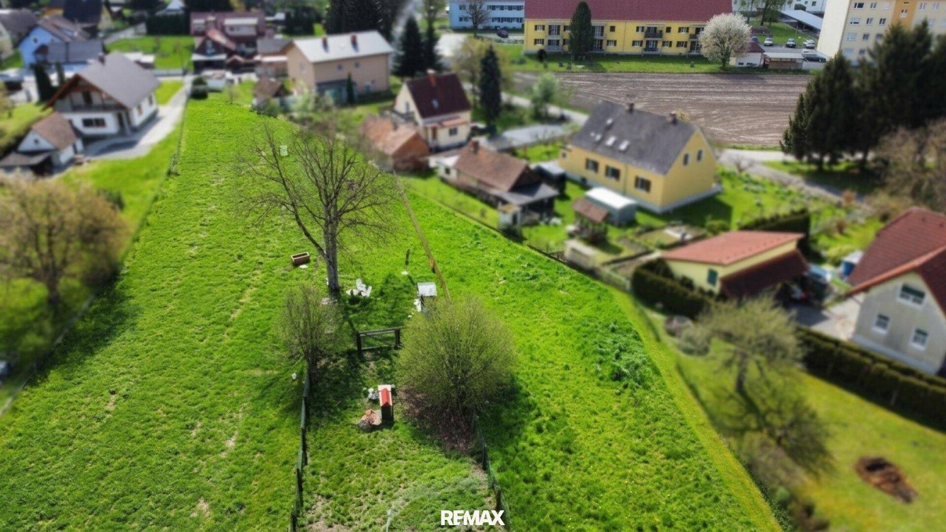 Überblick aus der Luft über das weitläufige grüne Grundstück und die angrenzende Wohnbebauung in ländlicher Lage.