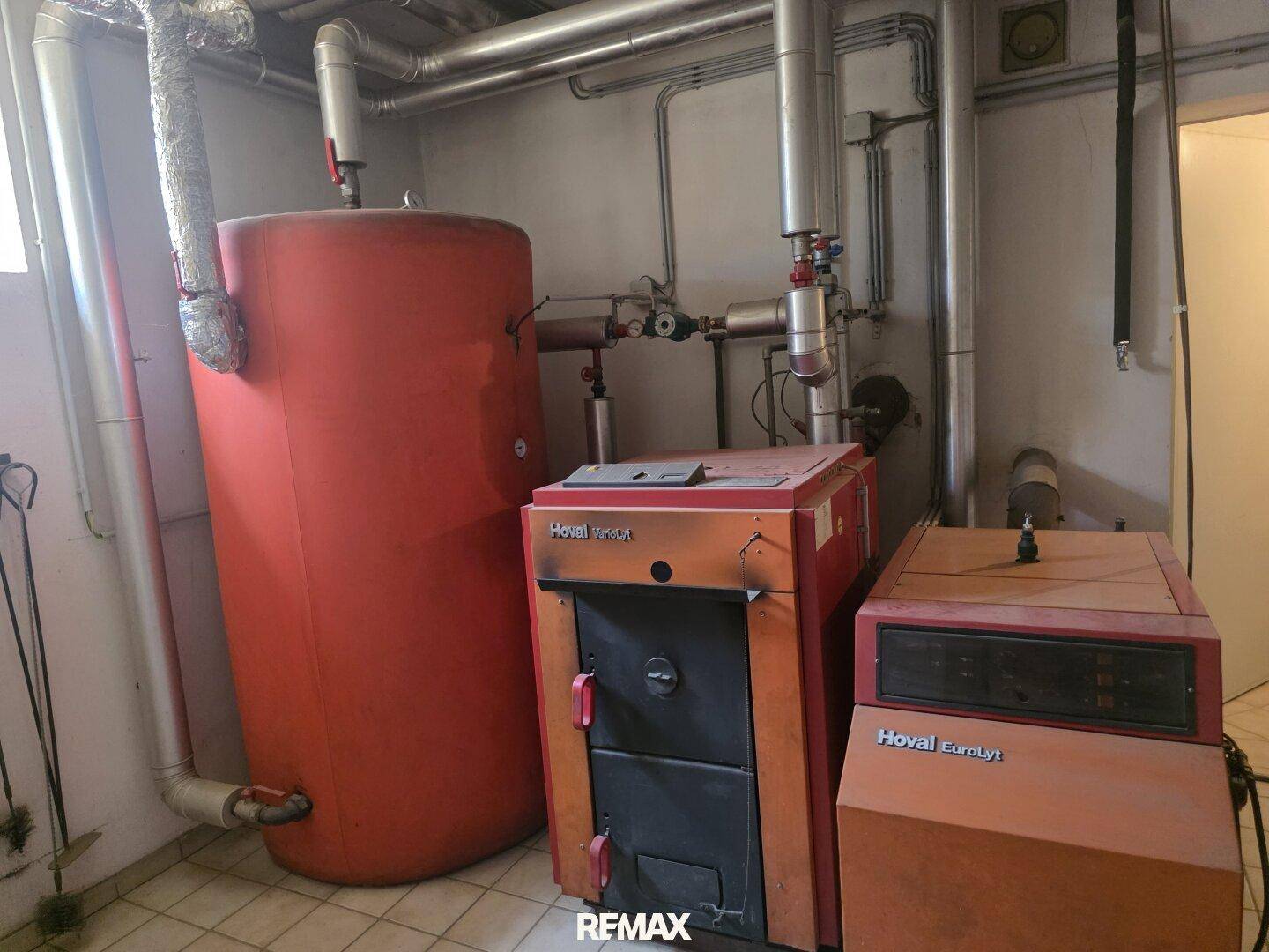 Heizkessel und Warmwasserspeicher der Marke Hoval in einem funktionalen Technikraum.