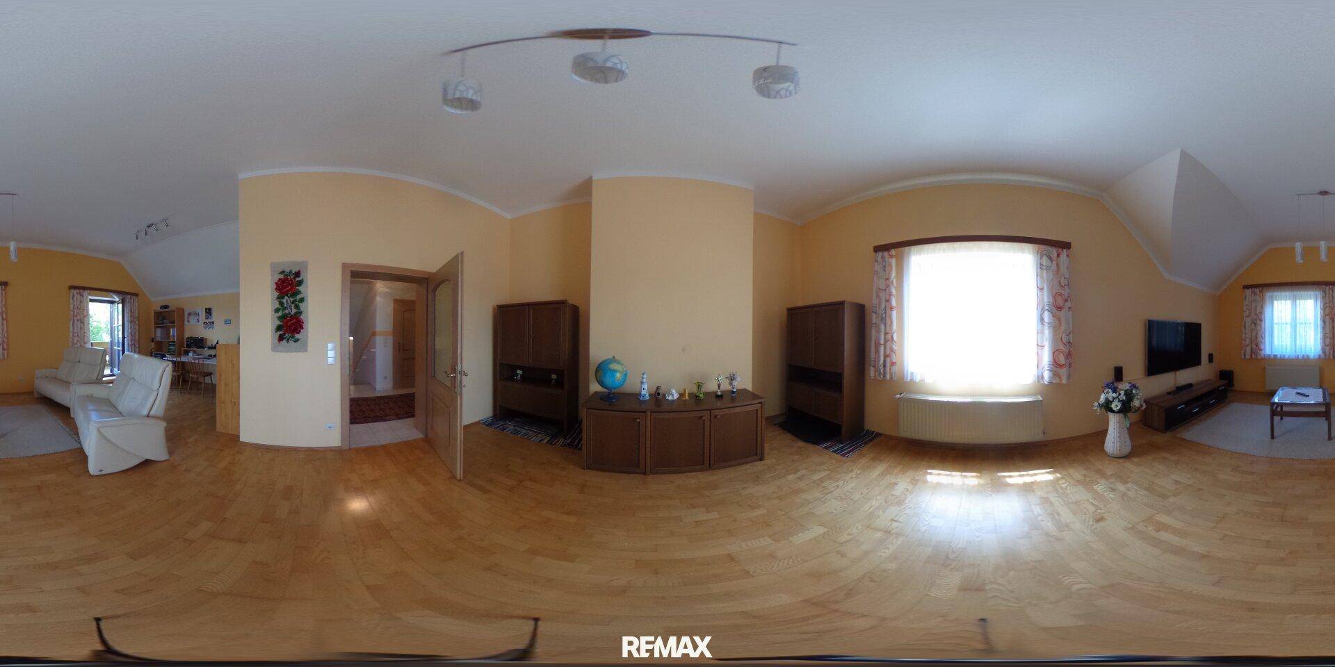 Geräumiges Wohnzimmer mit Parkettboden, hellgelben Wänden und großen Fenstern für viel Tageslicht.