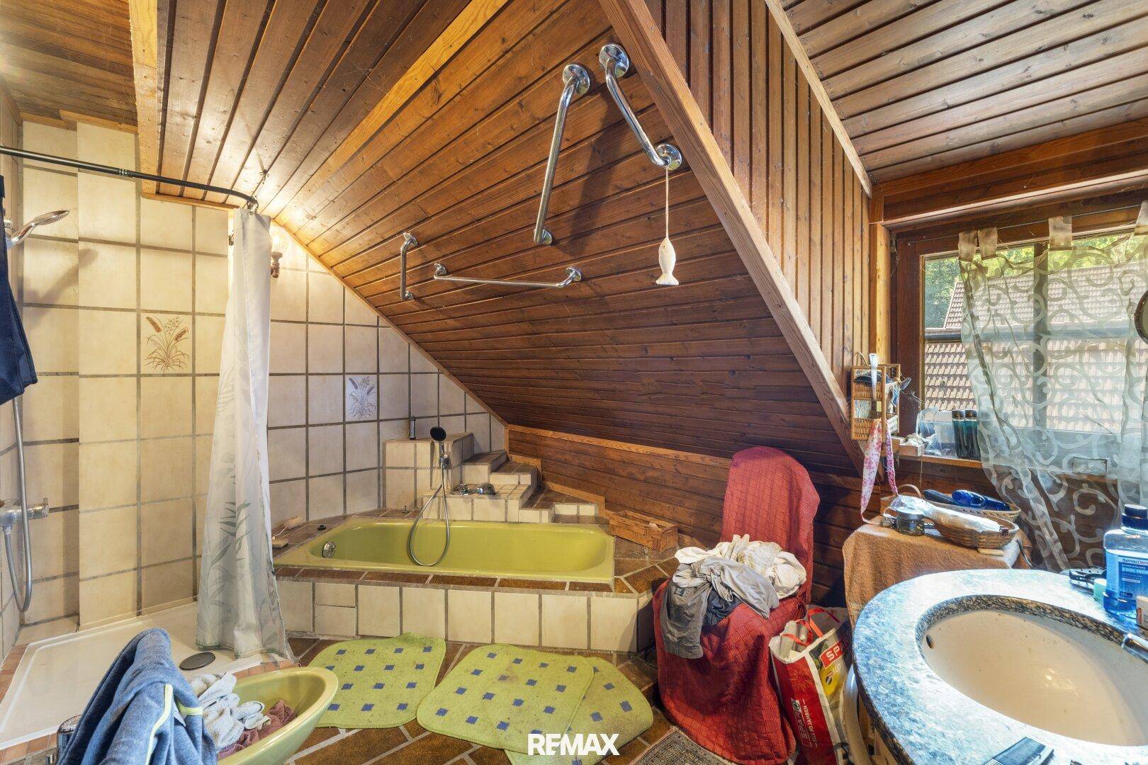 Rustikales Badezimmer mit Eckbadewanne, Duschbereich und Holzverkleidung an der Decke.