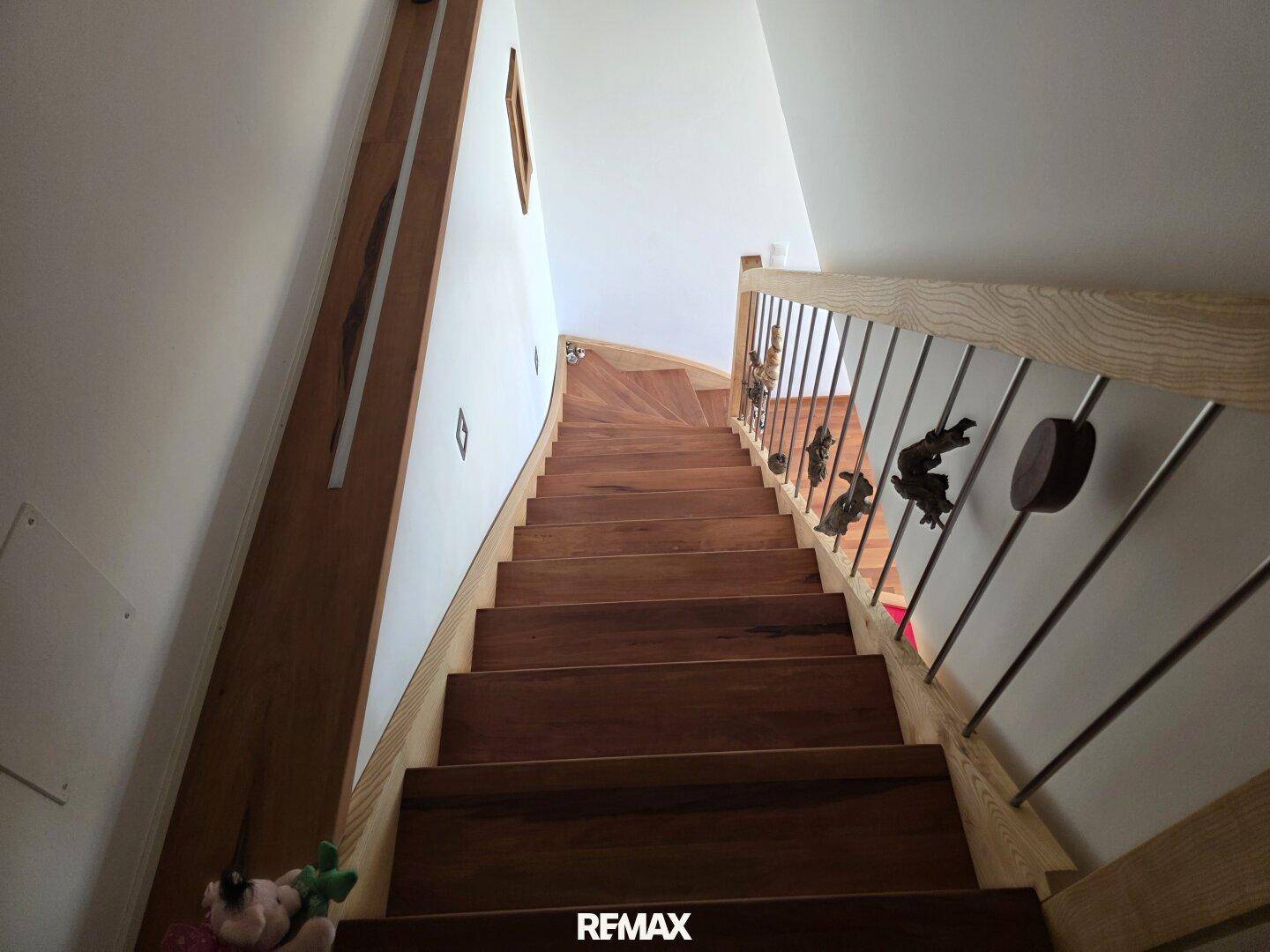 Elegante Holztreppe mit Metallgeländer, die die verschiedenen Etagen des Hauses verbindet.