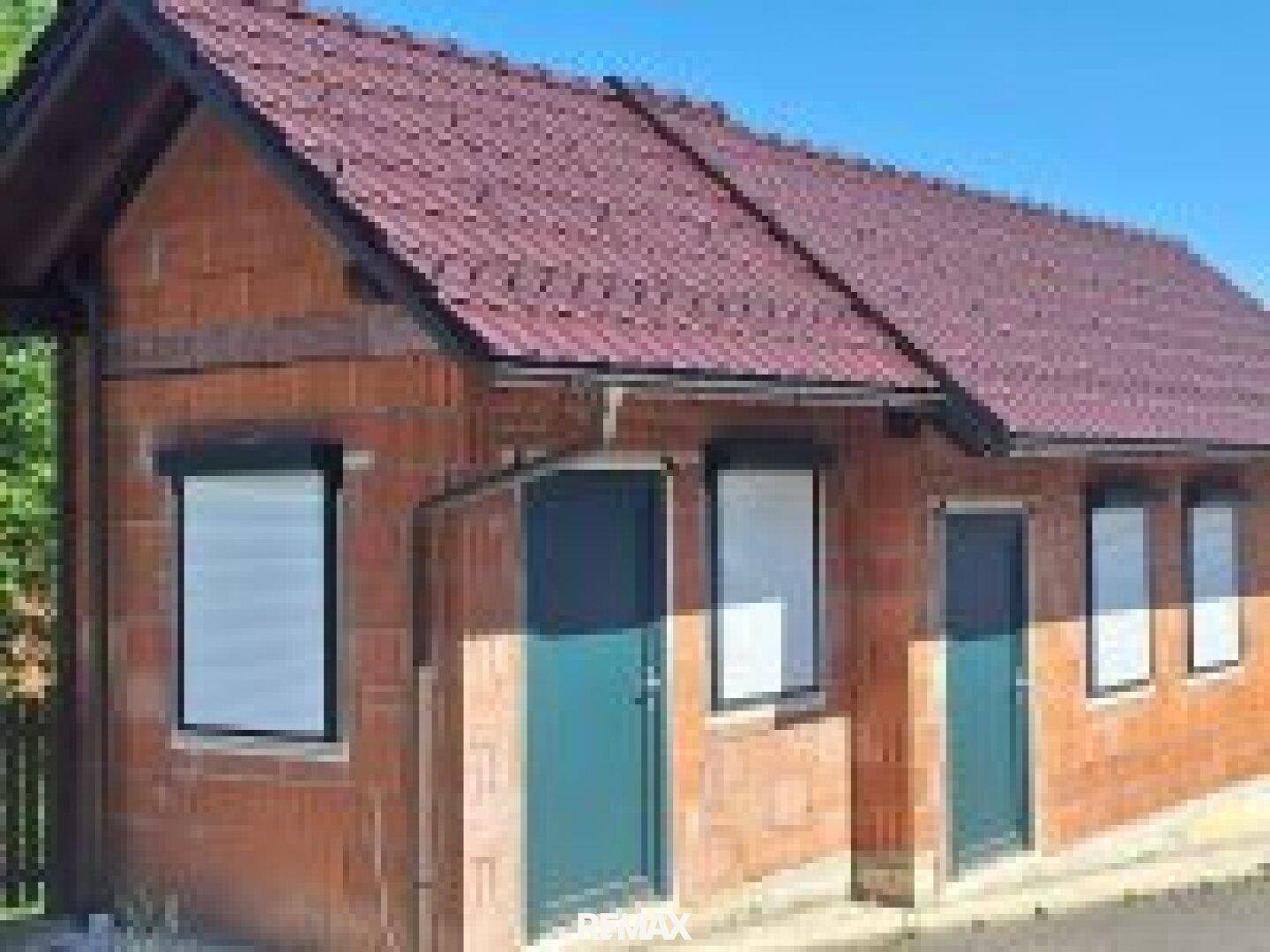 Kleineres Nebengebäude aus Ziegeln mit Fenstern und Türen, möglicherweise ein Gartenhaus oder Abstellraum.