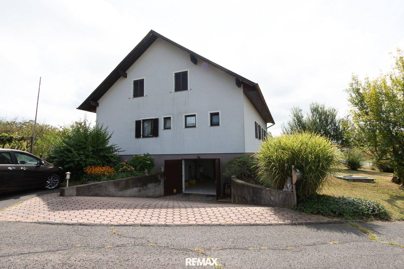 Einfahrt zur Garage im Untergeschoss des Hauses mit gepflastertem Vorplatz.