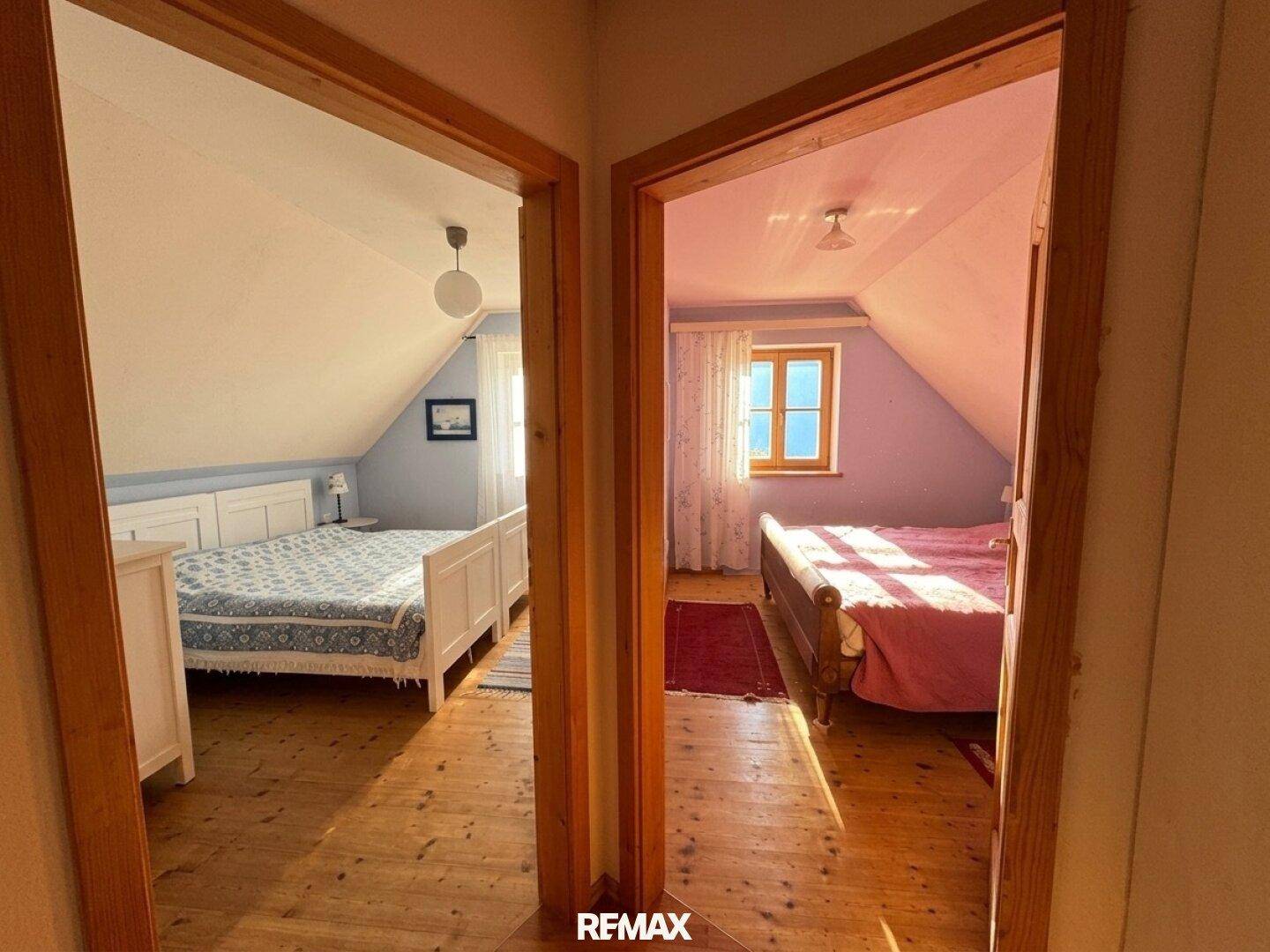Flur mit Blick in zwei helle Schlafzimmer, die beide über Dachschrägen verfügen.