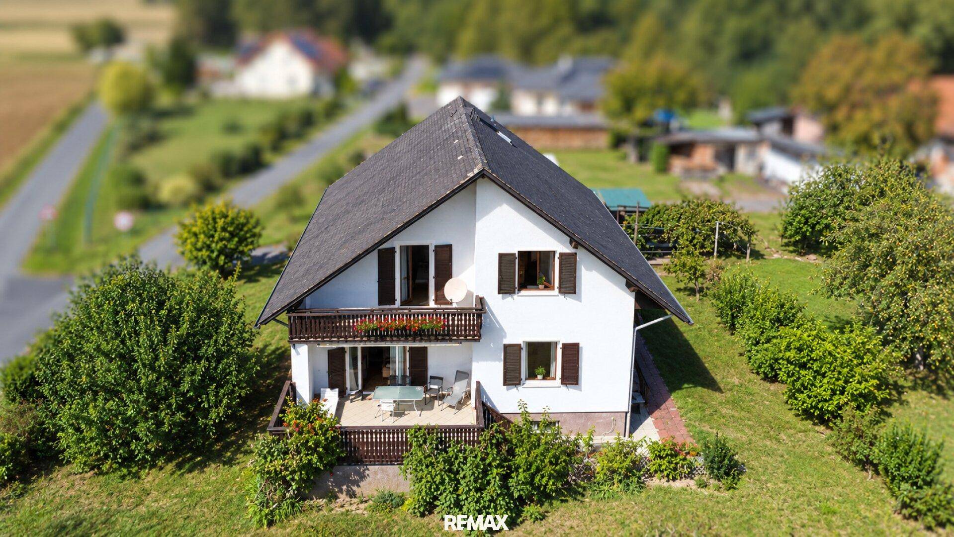Vogelperspektive eines Einfamilienhauses mit Garten und umliegender ländlicher Landschaft.