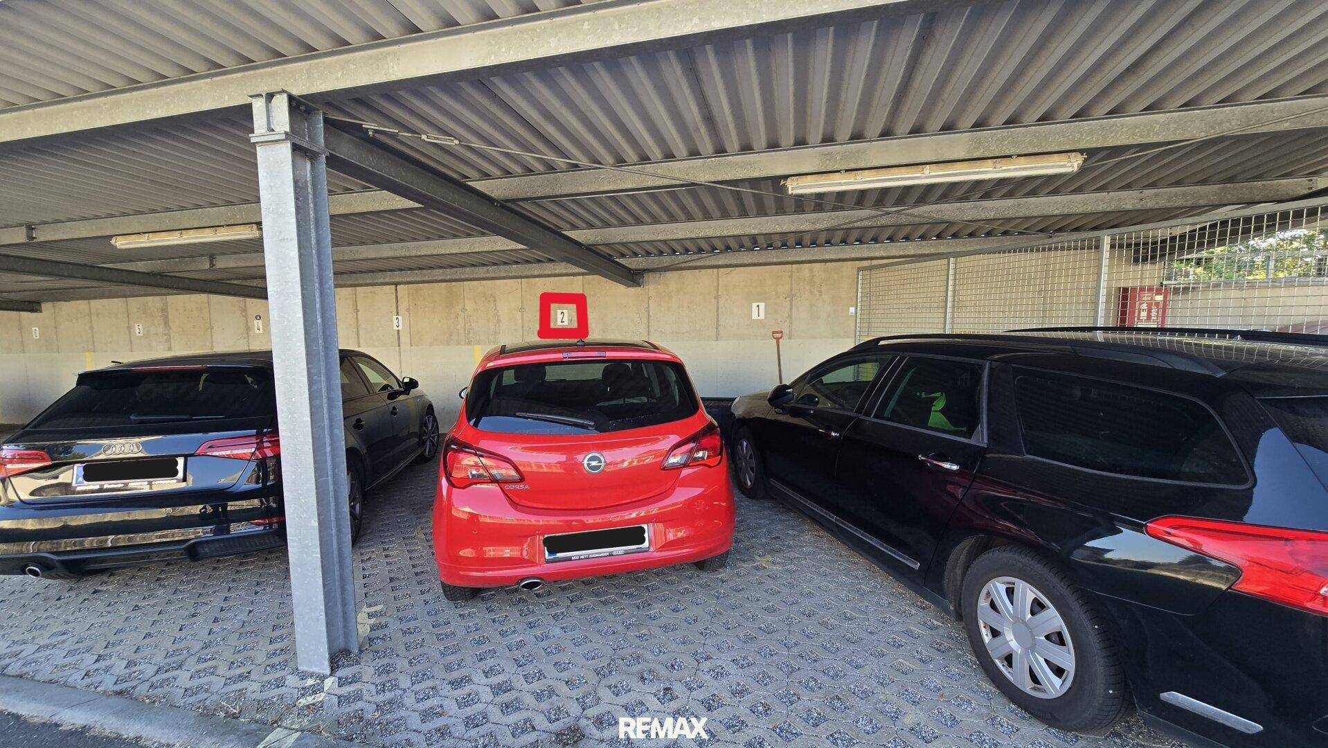 Überdachter Stellplatz in der Tiefgarage mit mehreren Parkmöglichkeiten für Fahrzeuge.