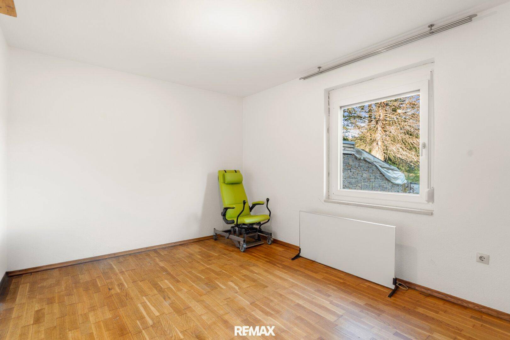 Helles, leeres Zimmer mit Holzboden und Fenster, bereit zur individuellen Gestaltung.