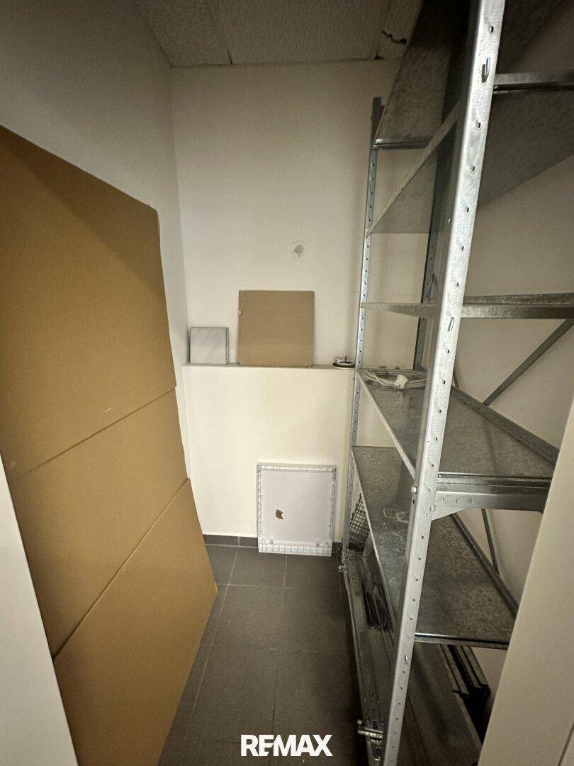 Lagerraum mit Metallregalen und Kartons, ideal für die Aufbewahrung von Büromaterial.