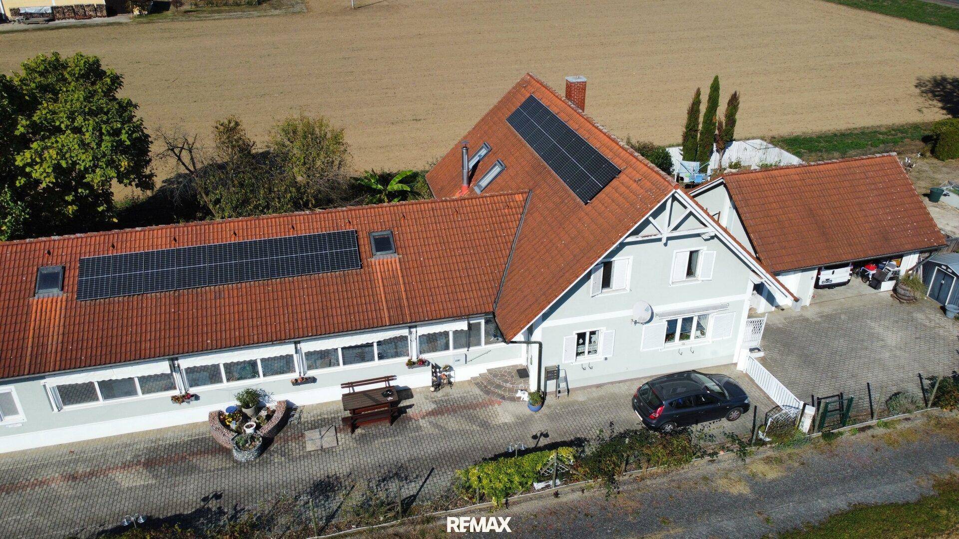 Übersicht des Anwesens von oben mit Photovoltaikanlage und angrenzenden Feldern.