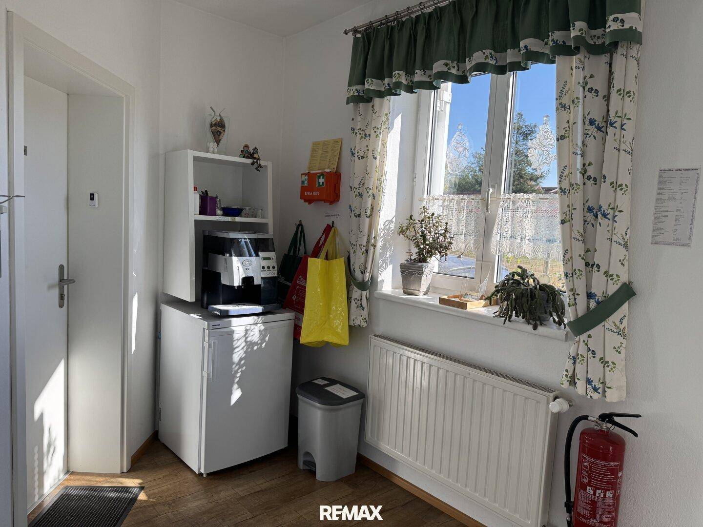 Kleiner Bereich mit Fenster, Kaffeemaschine, Minikühlschrank und Feuerlöscher.