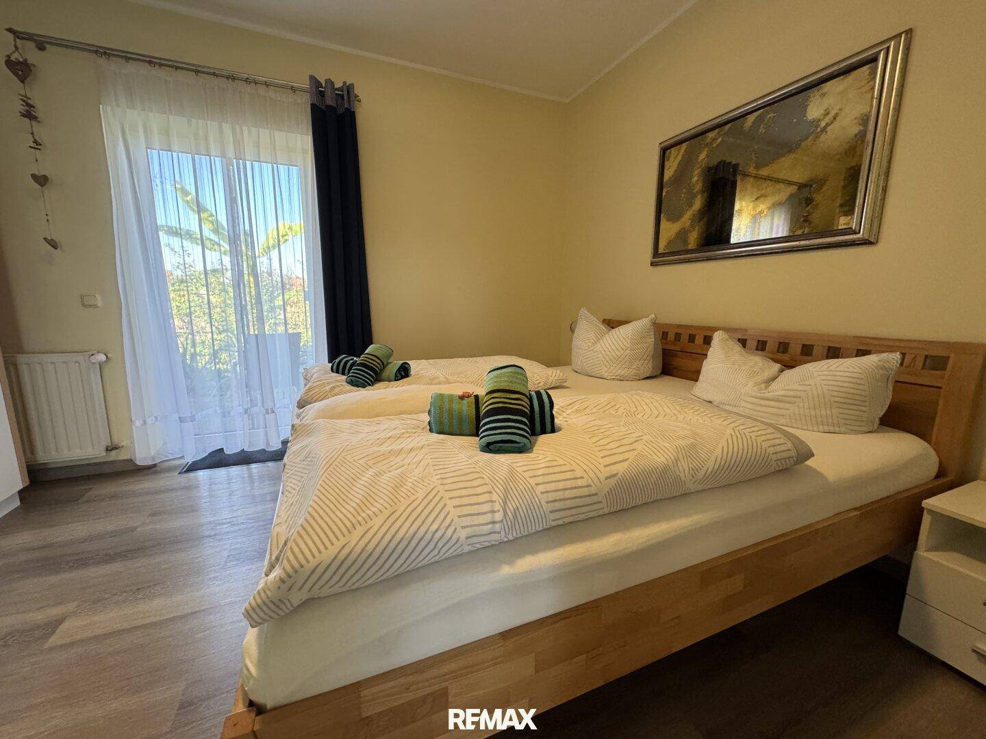 Helles Schlafzimmer mit zwei Einzelbetten und direktem Zugang zum Außenbereich.
