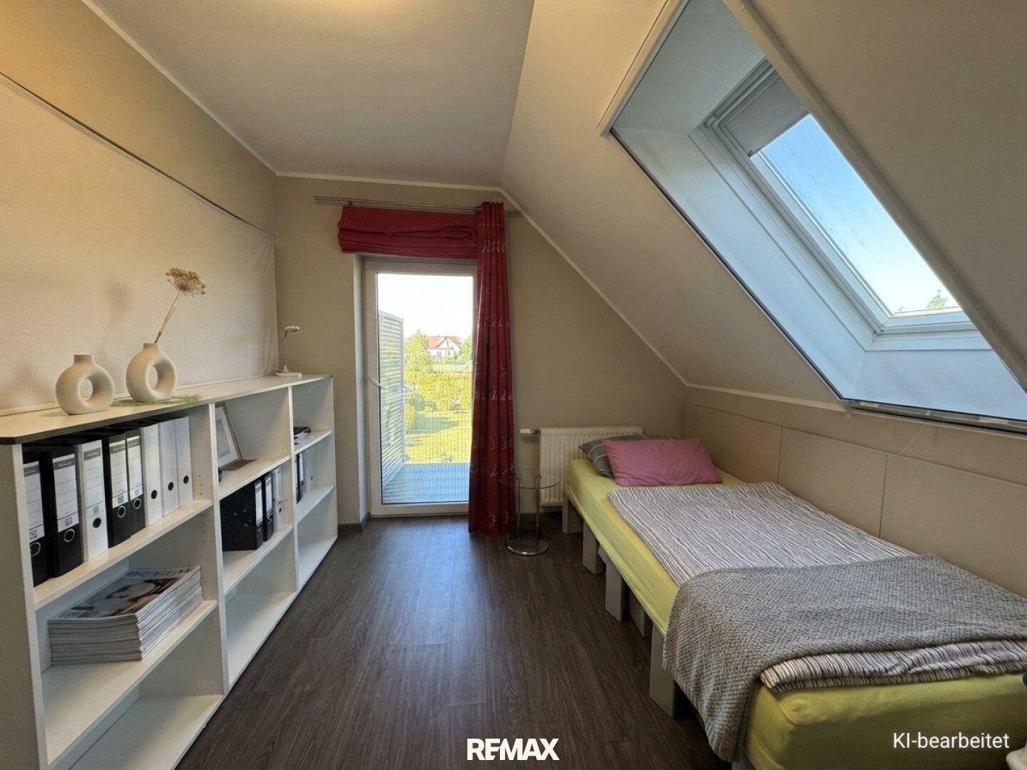 Dachgeschosszimmer mit Einzelbett, Regalen, Dachfenster und Zugang zu einem Balkon.