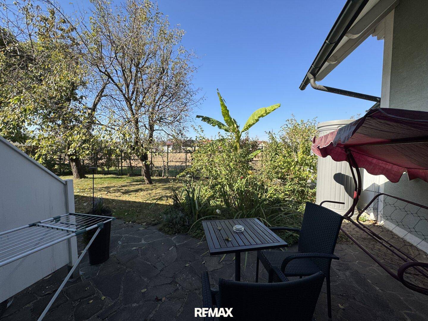 Gemütliche Terrasse mit Sitzgelegenheiten und Blick auf den grünen Gartenbereich.
