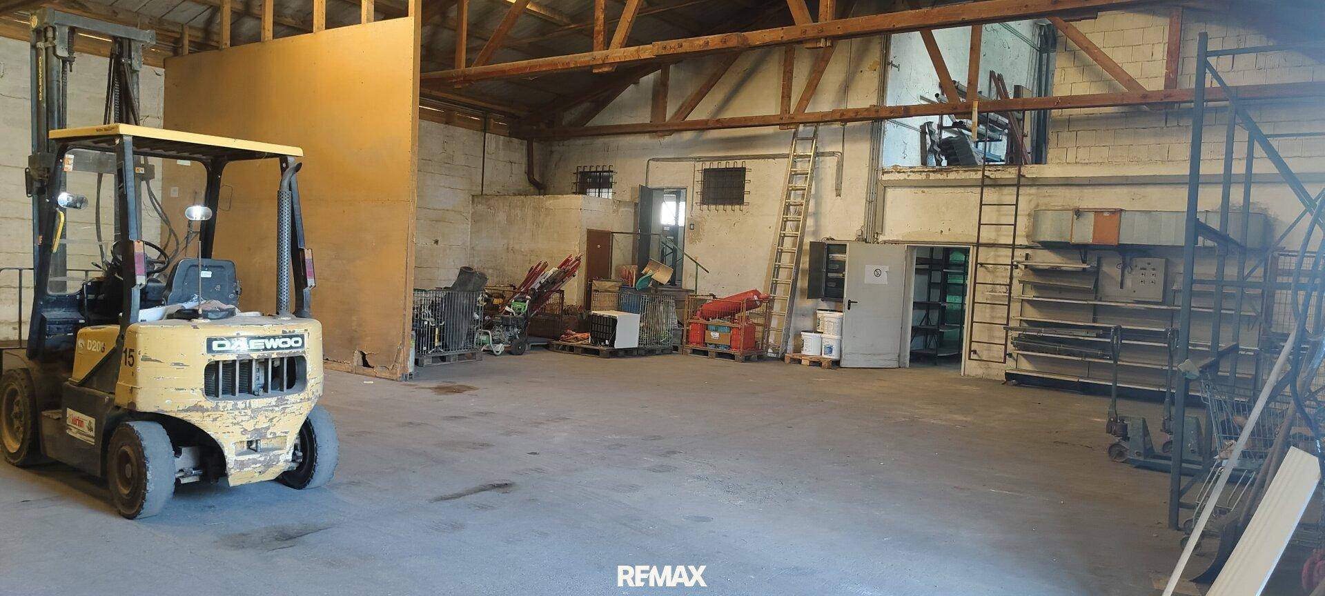 Großer Lagerraum mit Gabelstapler und Holzbalken an der Decke, ideal für Logistik.