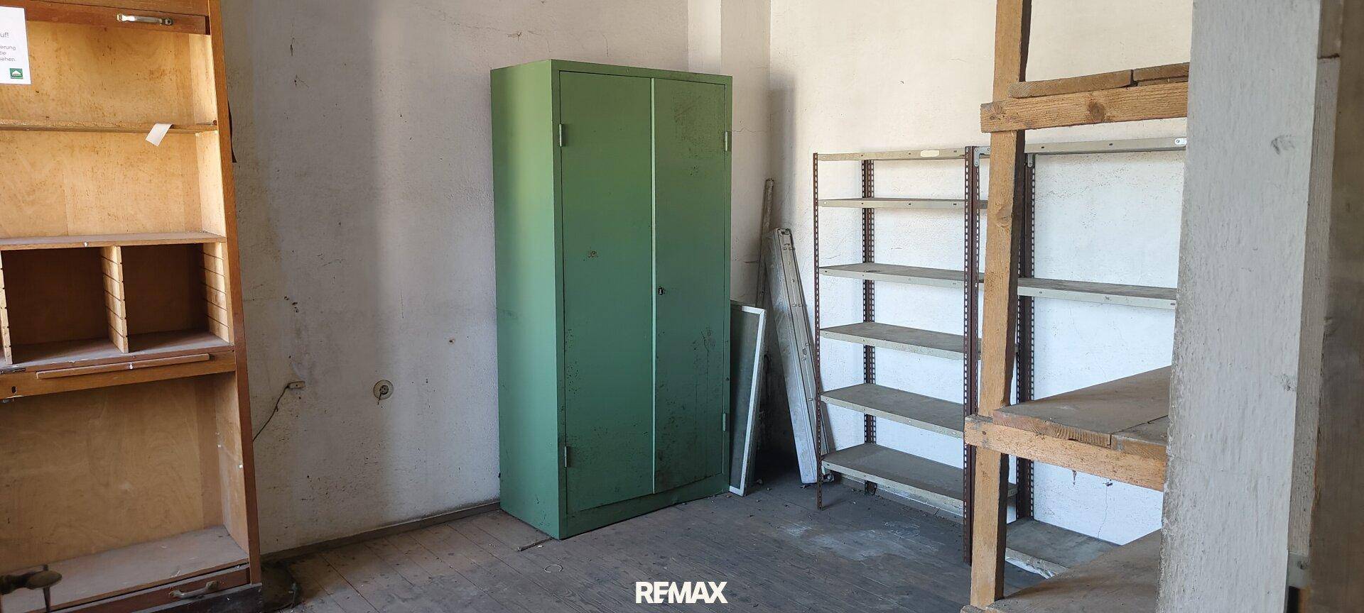 Lagerraum mit grünem Schrank und Holzregalen, bietet praktische Aufbewahrungsmöglichkeiten.