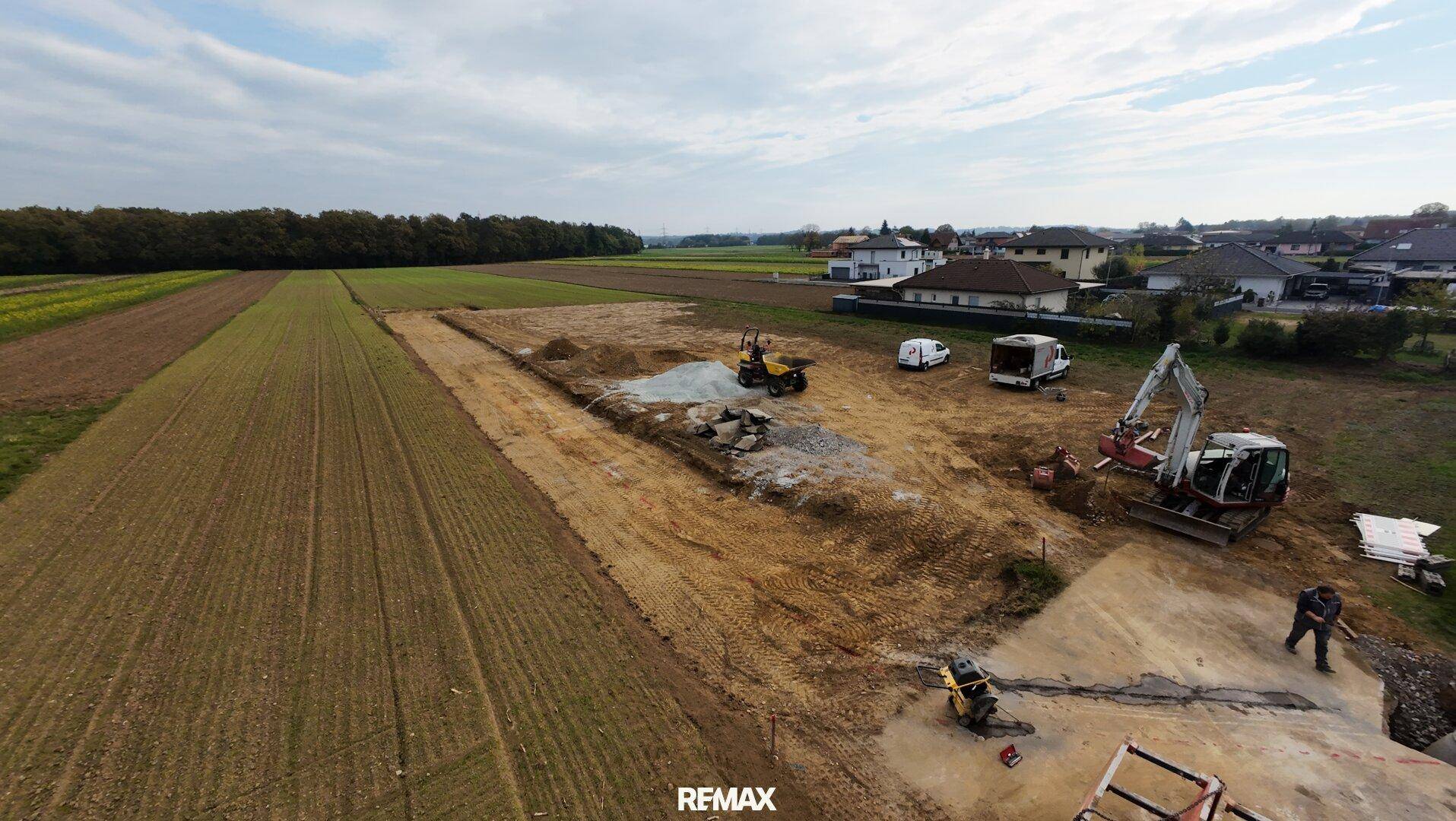 Baustelle mit Baggern und Erdbewegungen für die Erschließung neuer Wohnbaugrundstücke.
