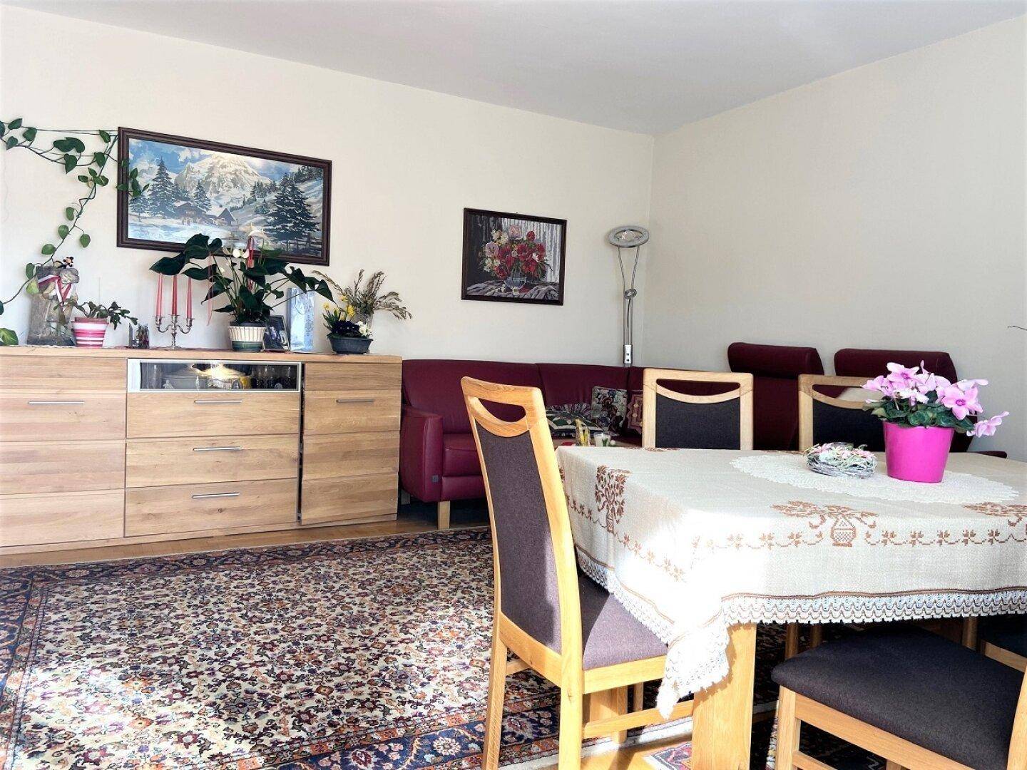 Wohn-Essbereich mit Esstisch und Sideboard, dekoriert mit Pflanzen und Bildern, einladend und hell.