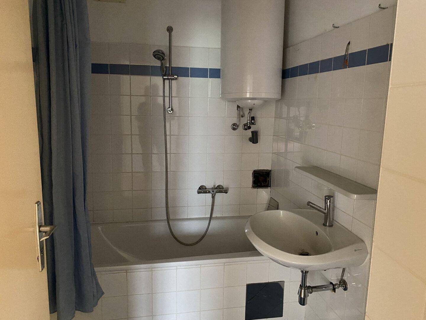 Badezimmer mit Badewanne, Duschvorhang, Waschbecken und weiß-blauen Fliesen im traditionellen Stil.