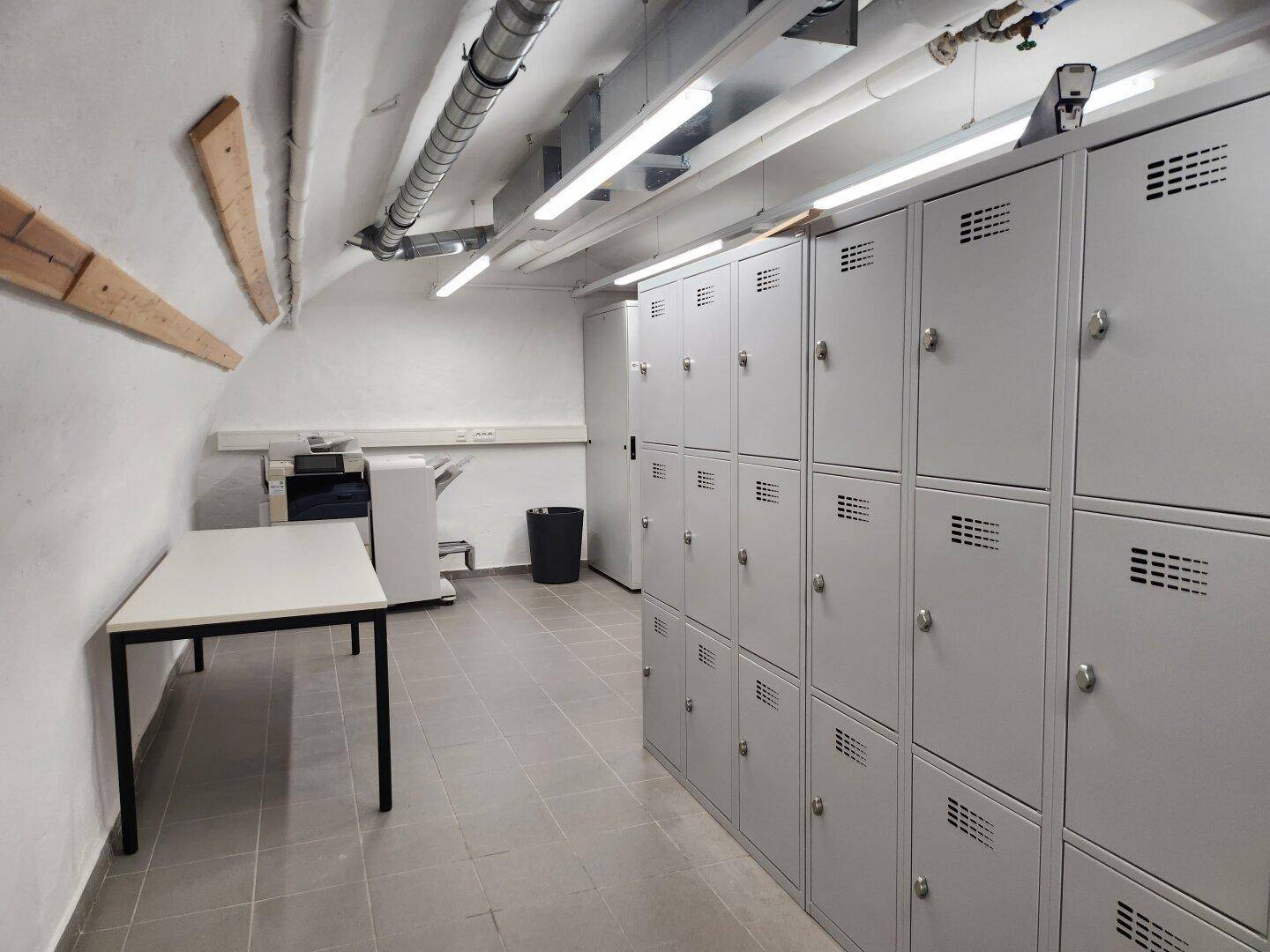 Lagerraum mit Reihen von Schließfächern, einem Tisch und gewölbter Decke, ideal für persönliche Gegenstände.