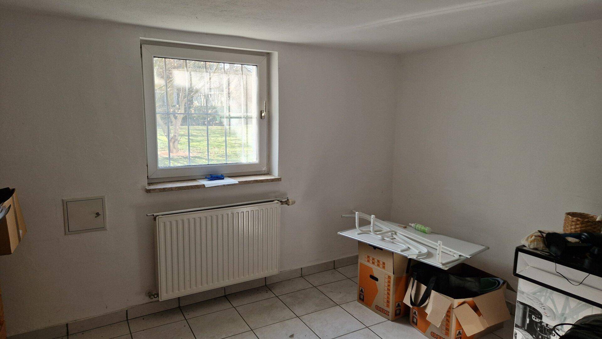 Abstellraum im Kellergeschoss mit Fenster und Fliesenboden.