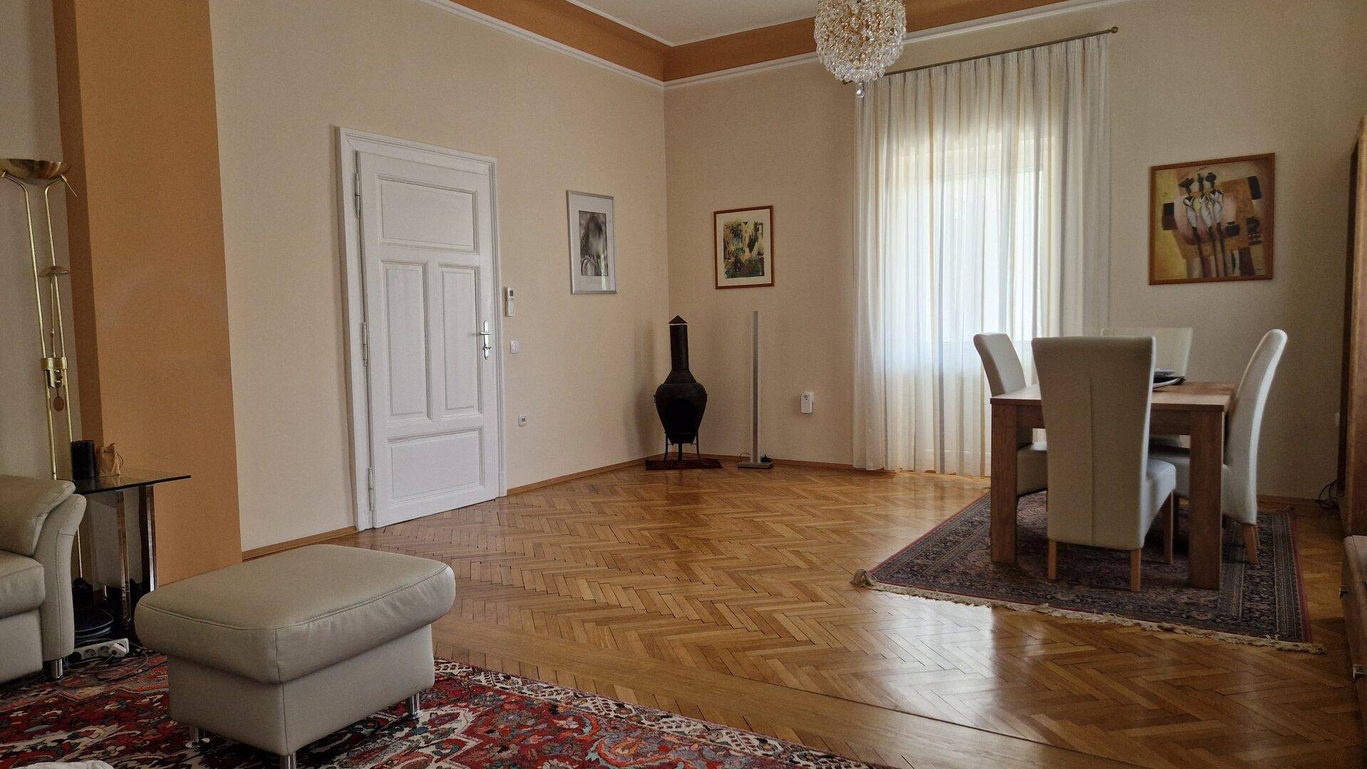 Essbereich im Wohnzimmer mit Holztisch, Stühlen und Parkettboden.