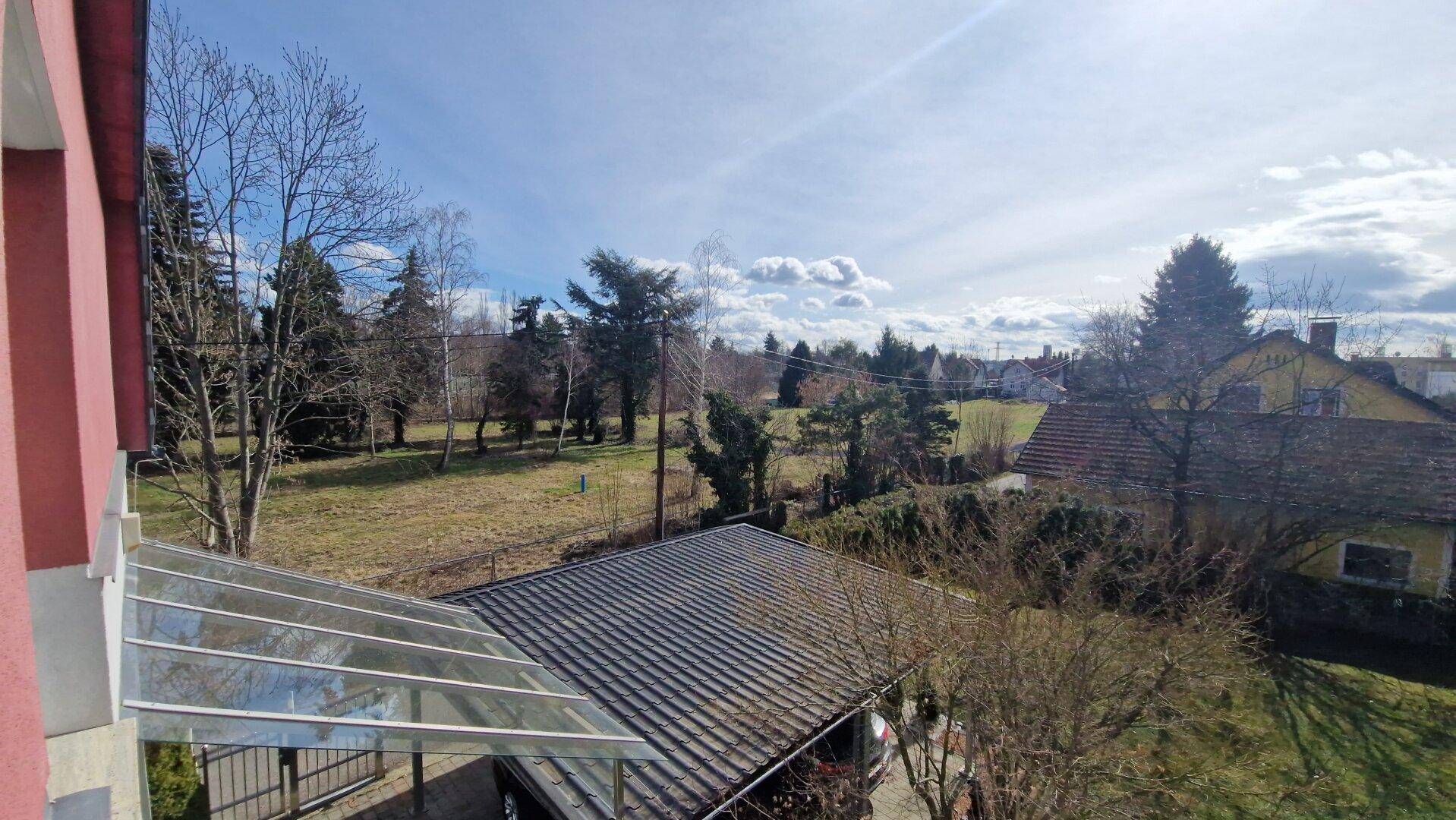 Weitläufiger Blick vom Balkon über die umliegende Landschaft und Dächer.