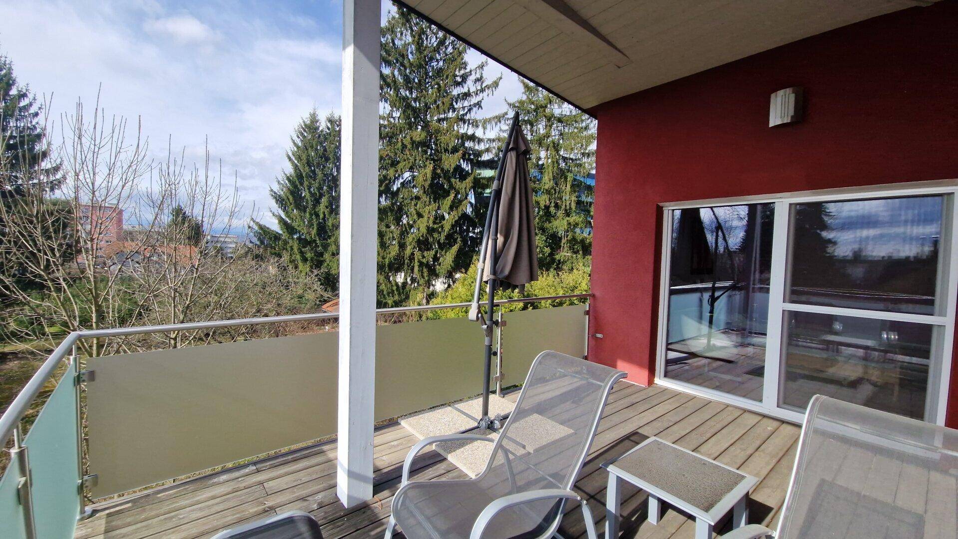 Geräumiger Balkon mit Sitzgelegenheiten und Blick ins Grüne.
