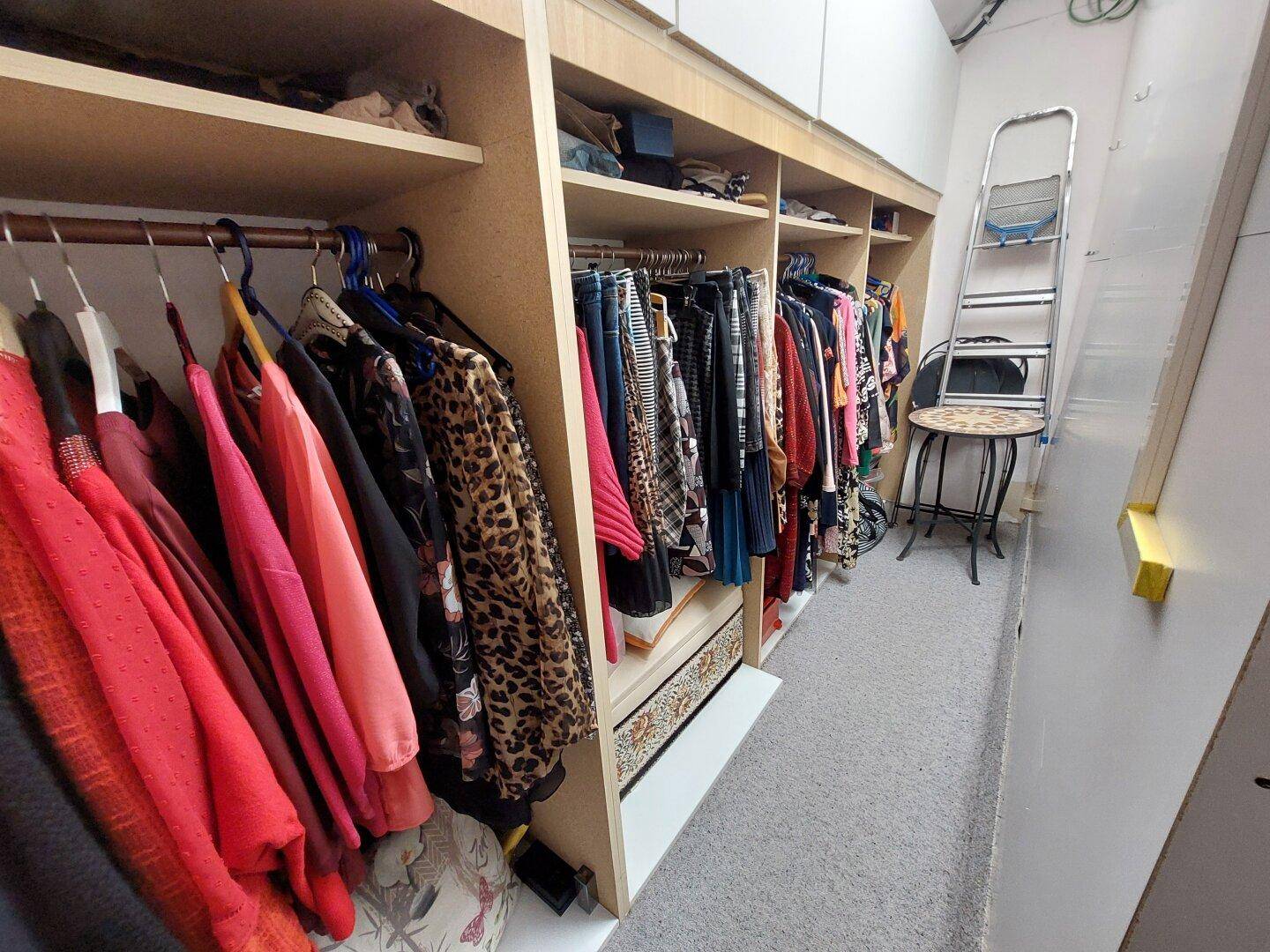Begehbarer Kleiderschrank mit Regalen und Kleiderstangen für viel Stauraum.