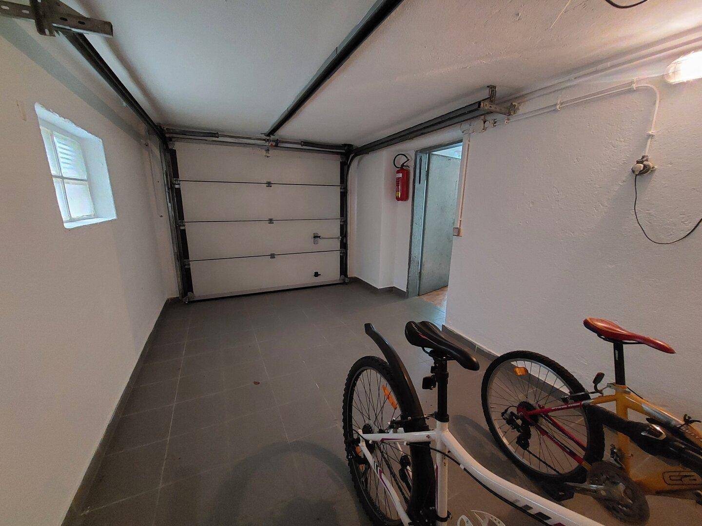 Geräumige Garage mit Sektionaltor und ausreichend Platz für Fahrräder und weitere Abstellmöglichkeiten.