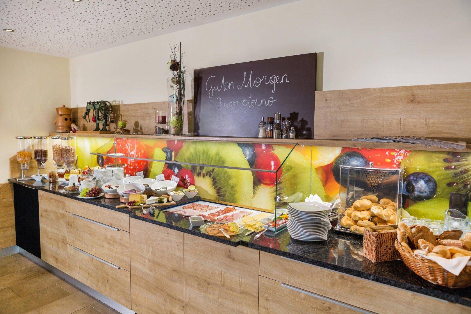 Reichhaltiges Frühstücksbuffet mit frischen Speisen, Aufschnitt und Gebäck in einem modernen Ambiente.