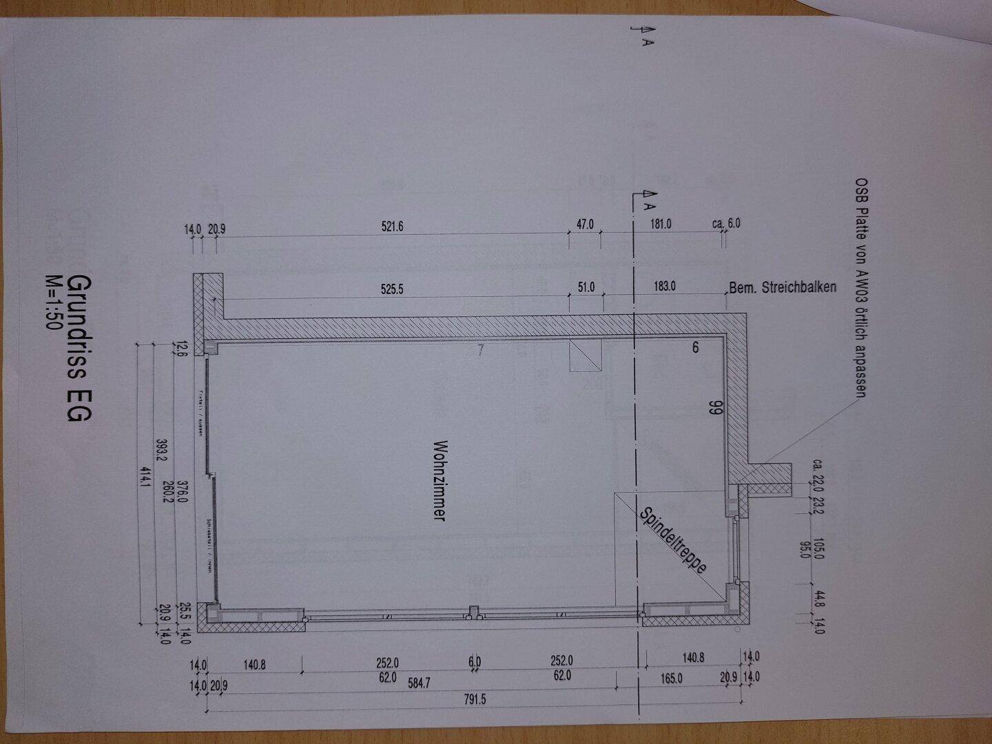 Grundriss des Erdgeschosses mit Wohnzimmer und Wendeltreppe.