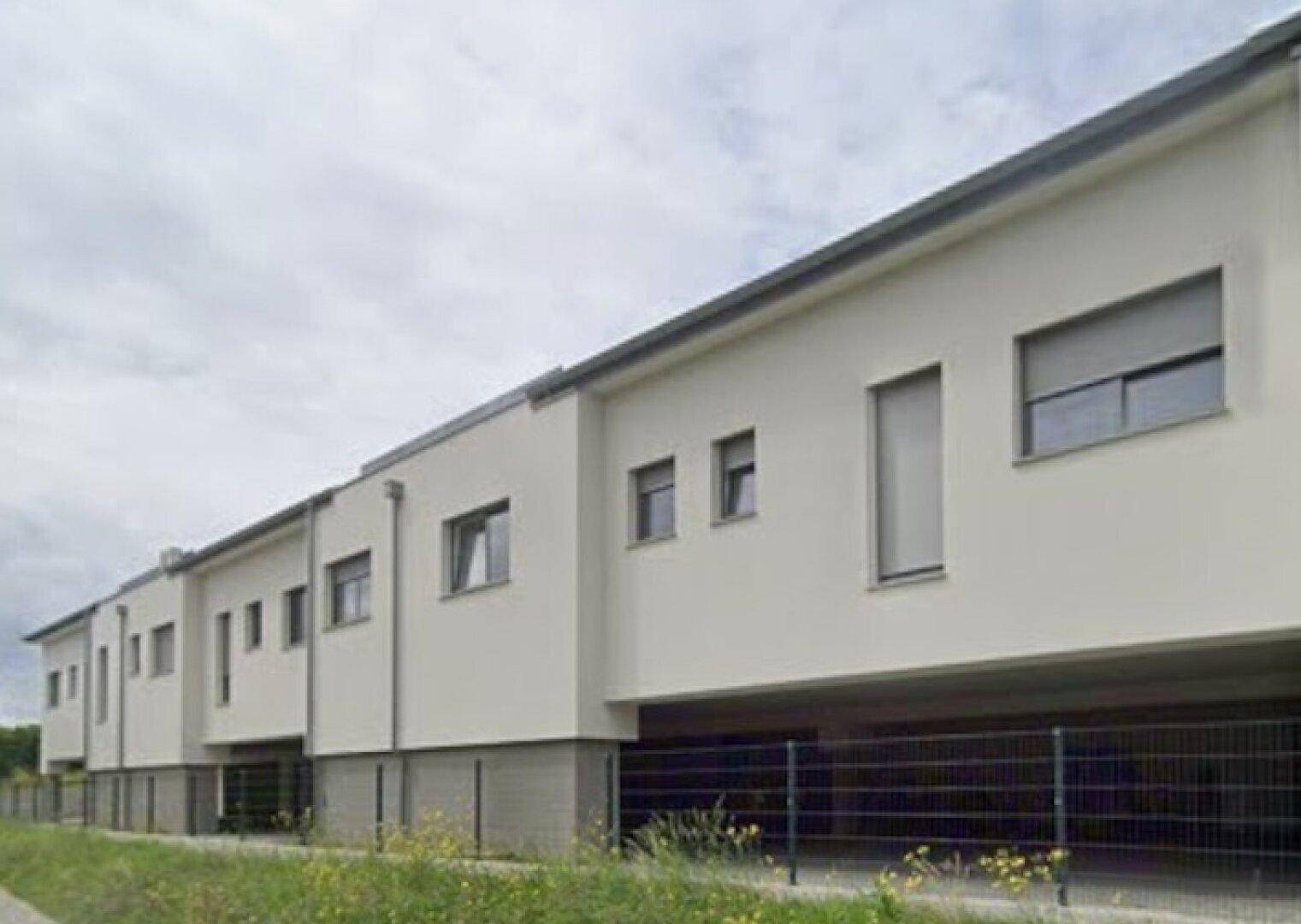 Ansicht der modernen Reihenhäuser mit schlichter Architektur und großen Fenstern.