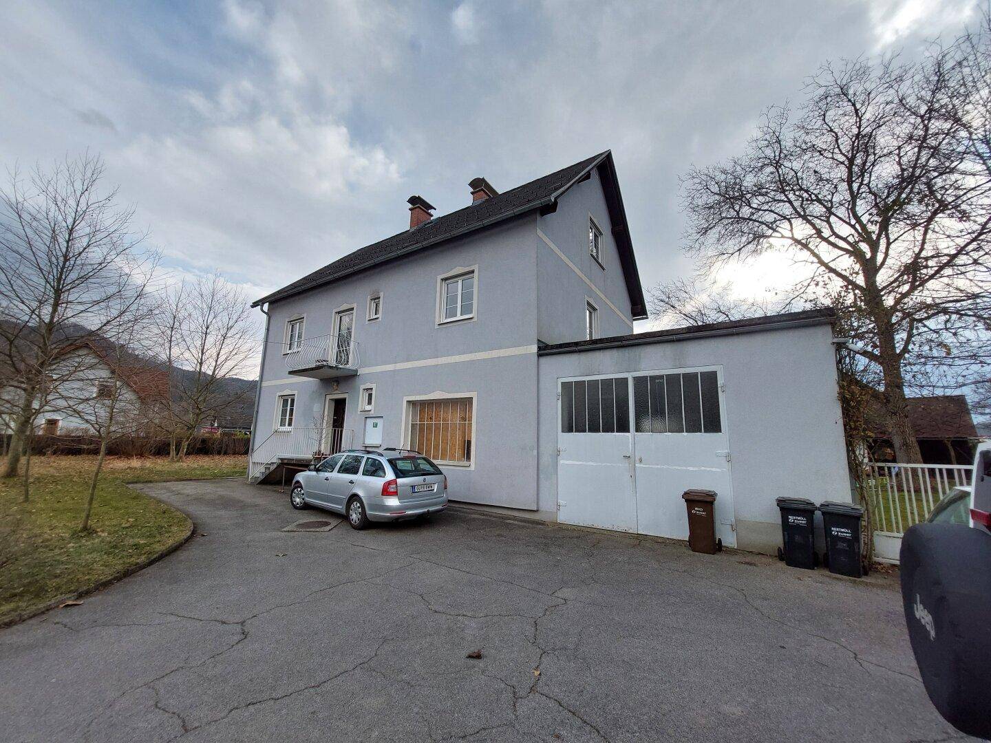 Ansicht des Wohnhauses mit integrierter Garage und Stellplatz auf dem Vorplatz.