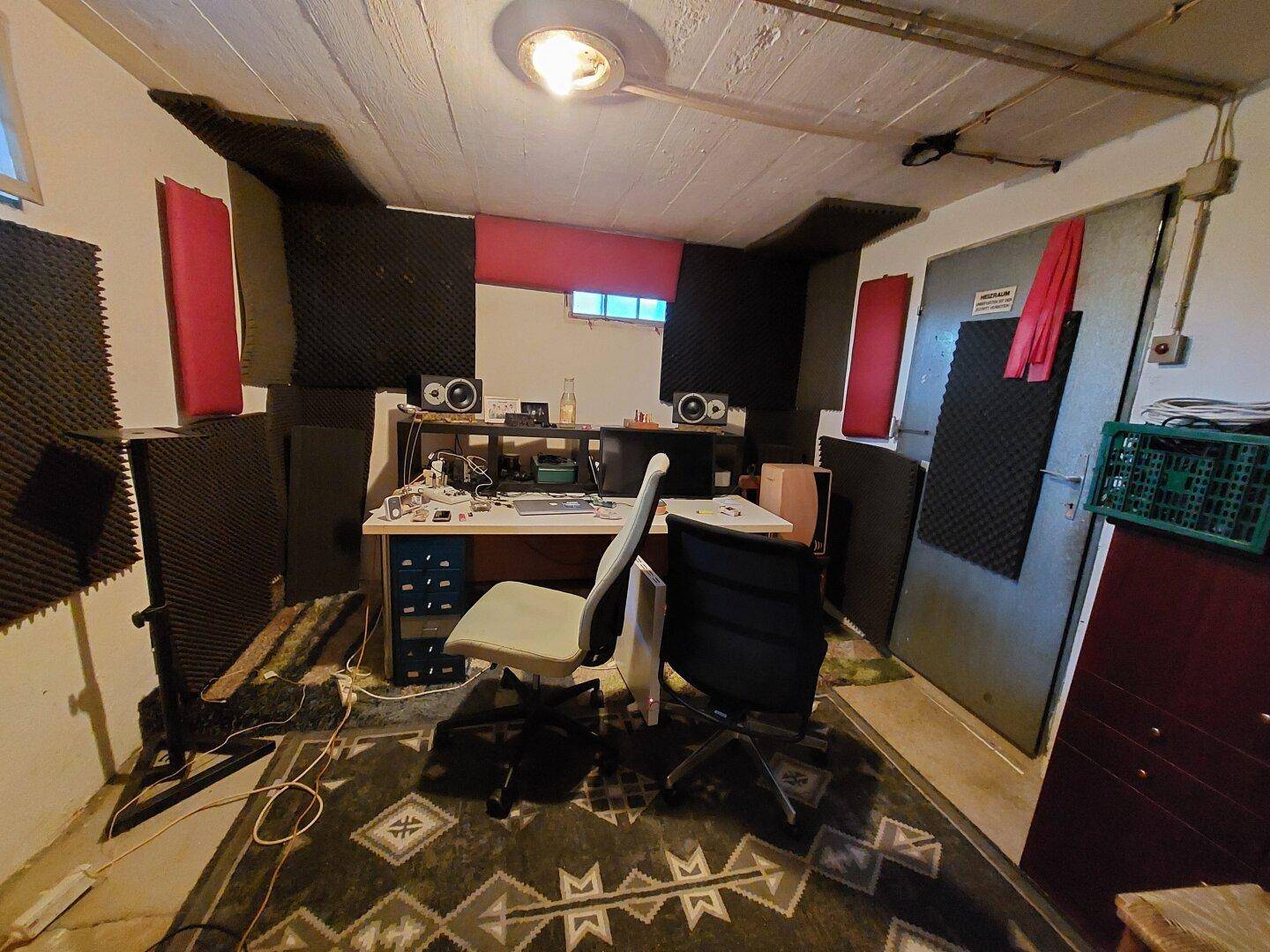 Kreativer Arbeitsbereich mit Schreibtisch, Sounddämmung und Teppichboden im Untergeschoss.