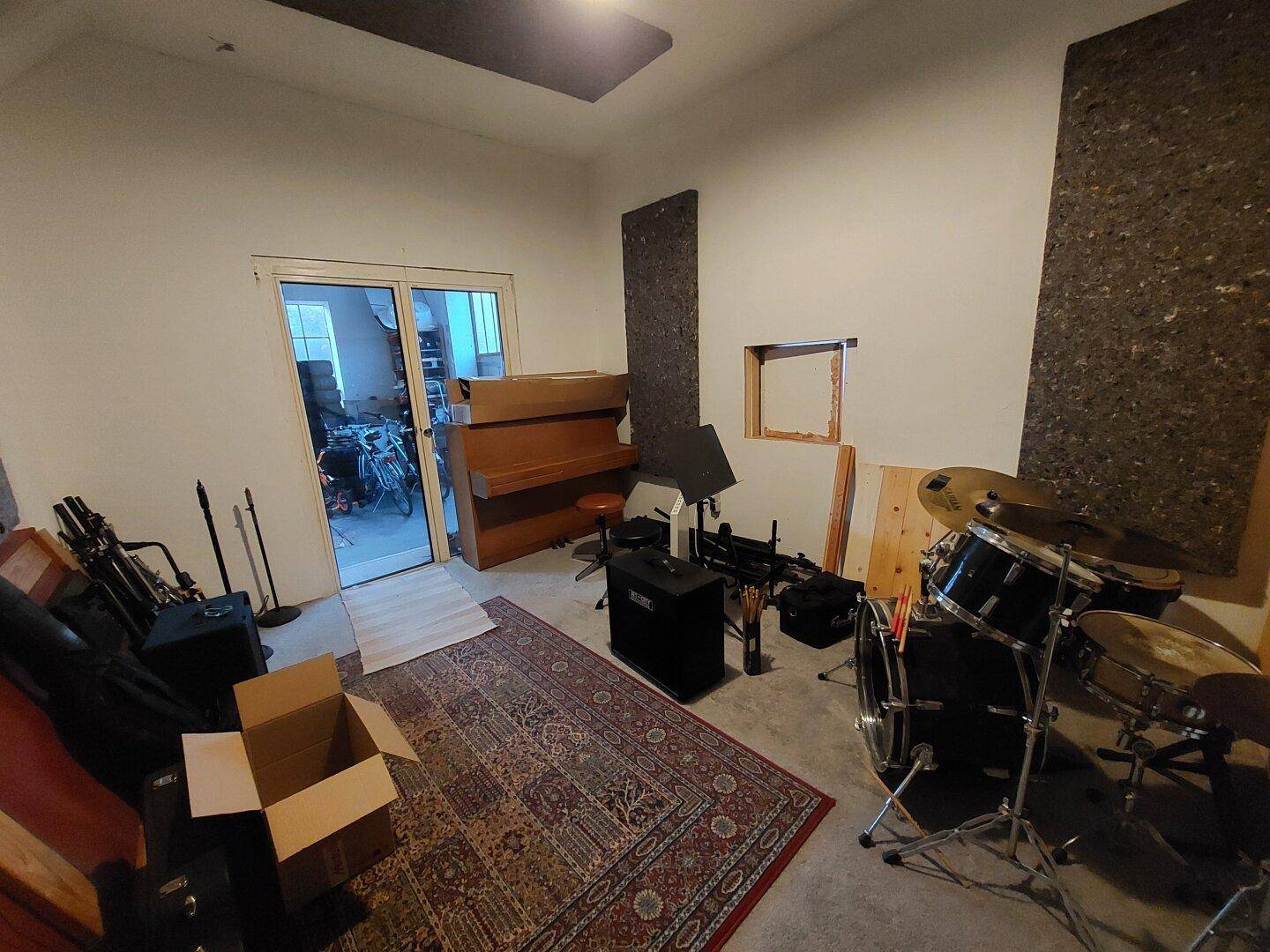 Musikzimmer mit Schlagzeug, Klavier und Teppichboden, ideal für Hobbymusiker.