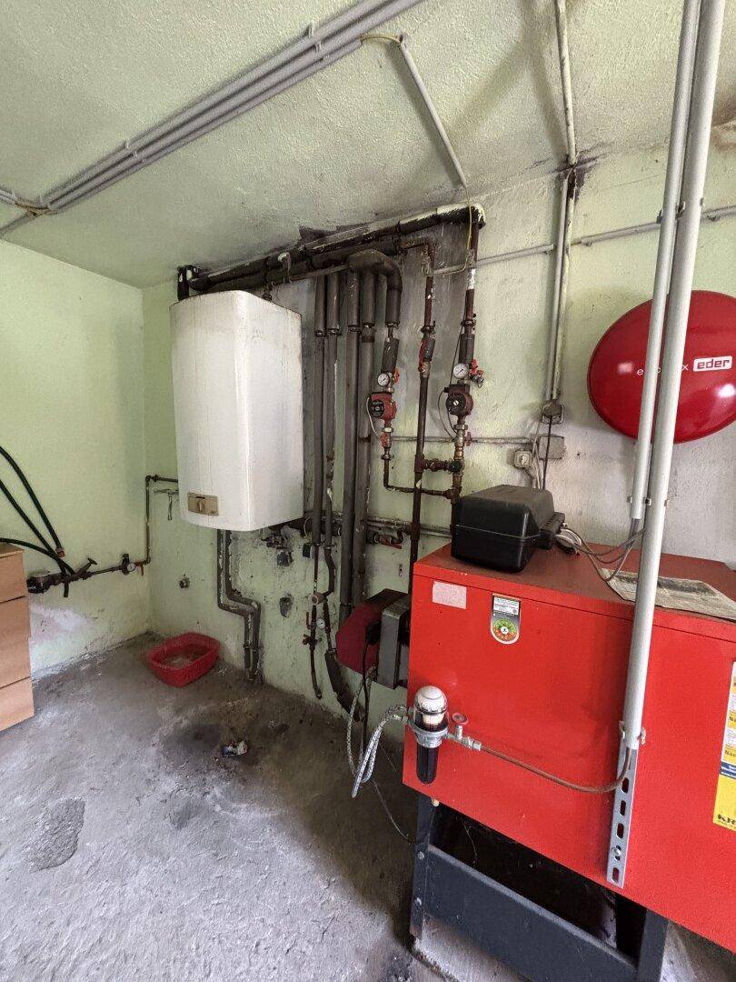 Heizungsraum mit Ölheizung und Warmwasserspeicher.