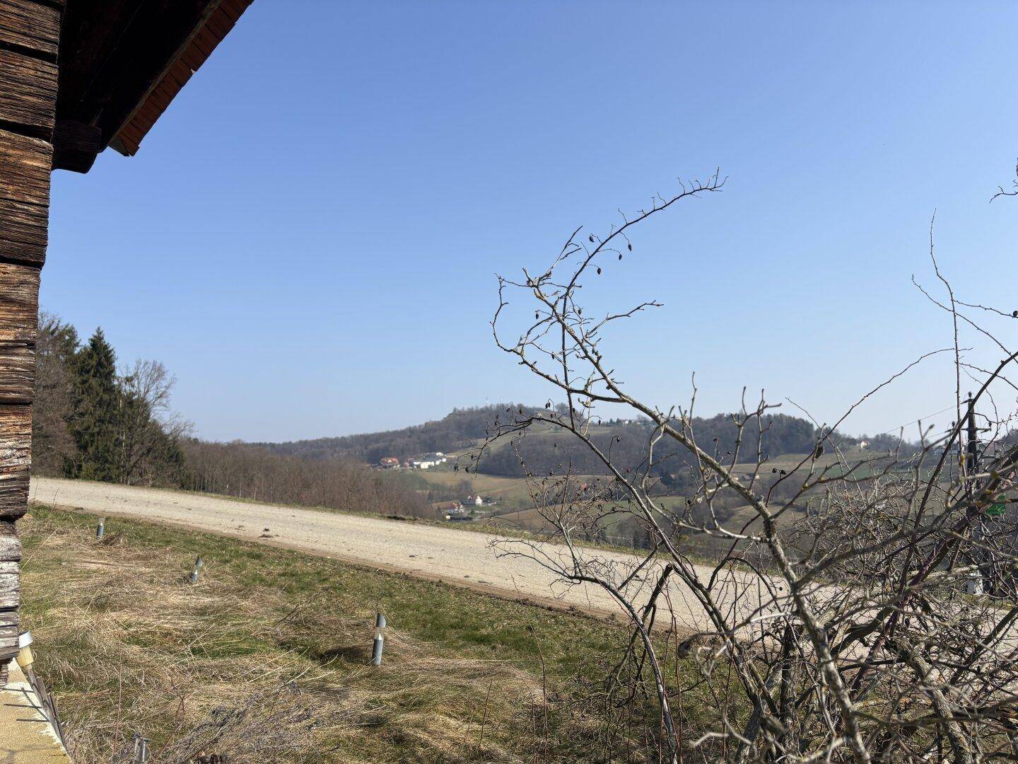 Weitläufiger Blick über die ländliche Landschaft mit Hügeln und Wegen.