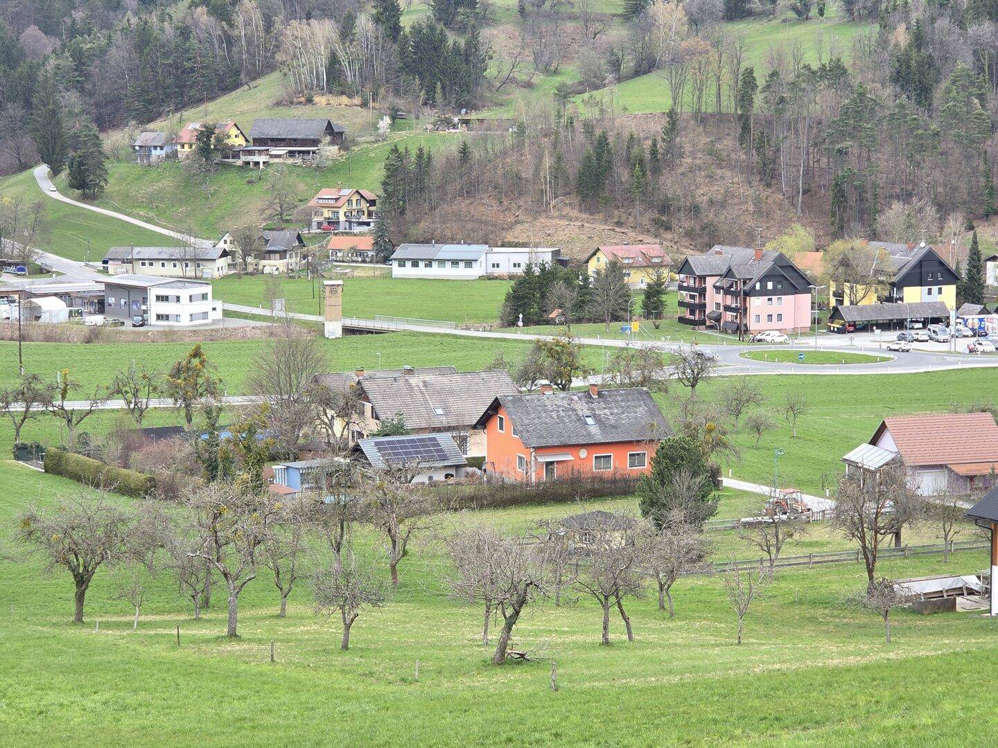 Weitläufiger Blick auf die ländliche Umgebung mit mehreren Häusern und grünen Hügeln.
