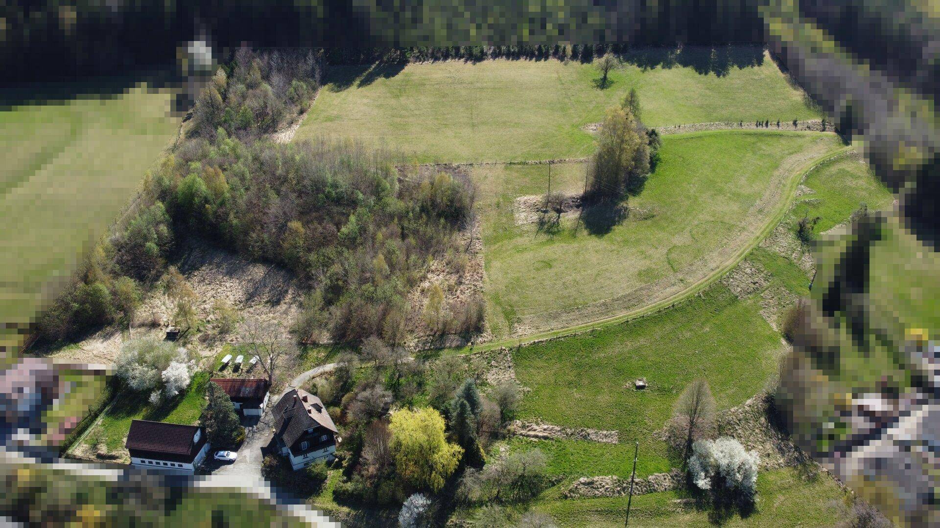 Luftaufnahme des Anwesens mit mehreren Gebäuden, Feldern und Wald in ländlicher Umgebung.