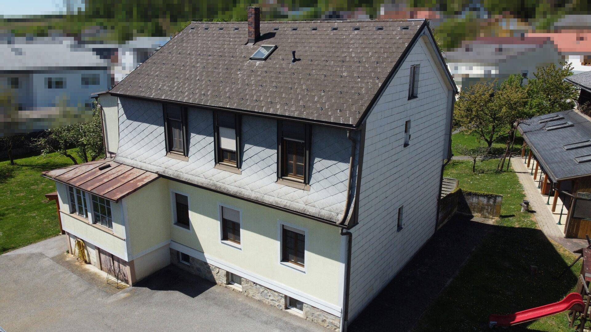 Rückansicht des Wohnhauses mit Satteldach, Gartenbereich und Dachfenster.