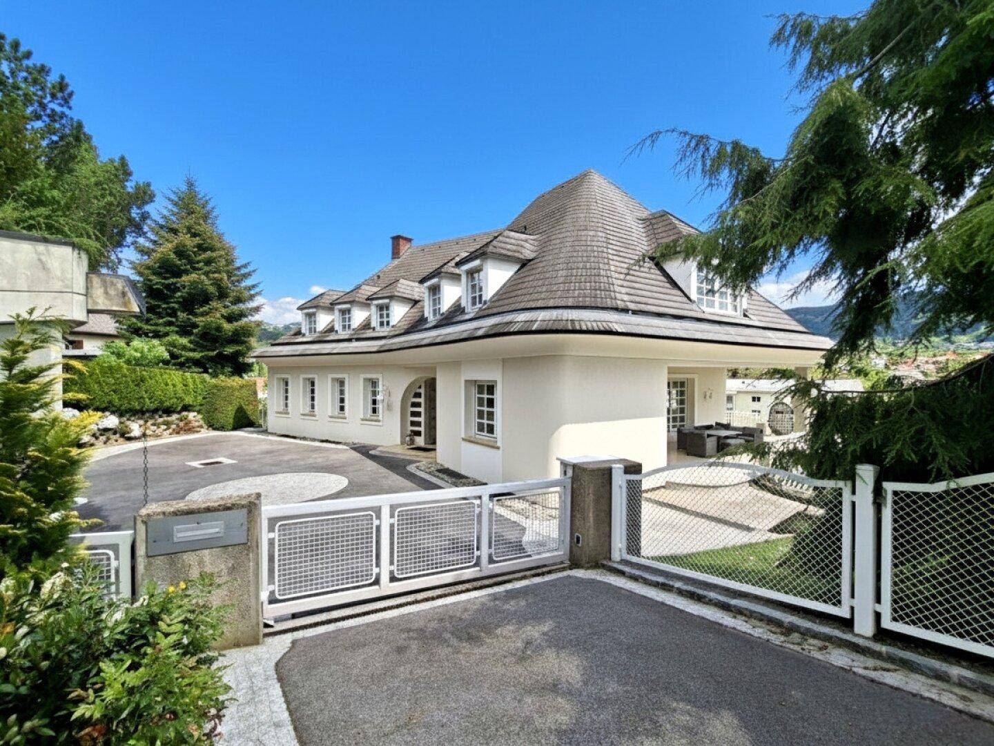 Repräsentative Villa mit großem Eingangsbereich, gepflasterter Auffahrt und sicherem Zugangstor.