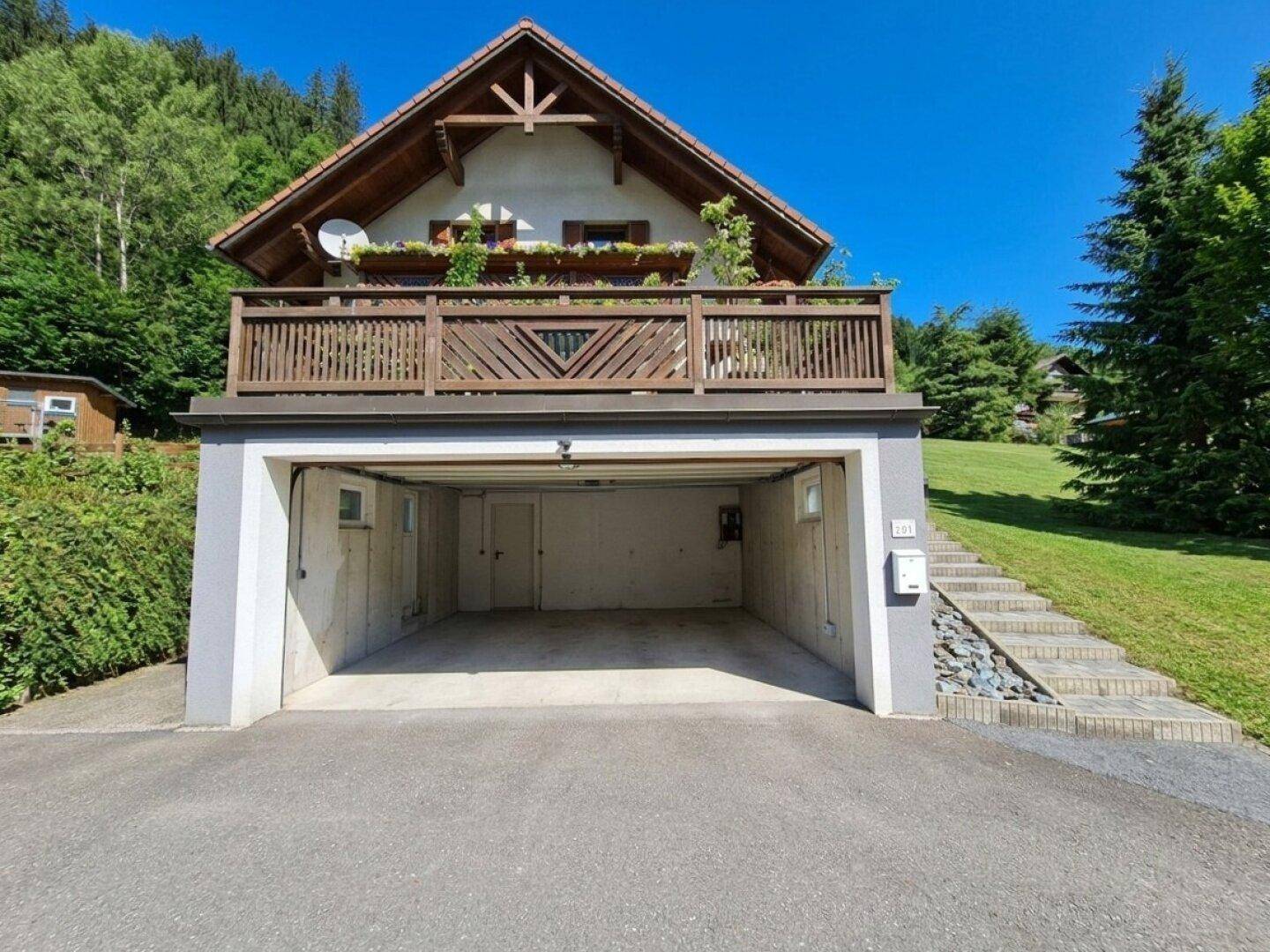 Vorderansicht des Hauses mit integrierter Doppelgarage und Außentreppe.