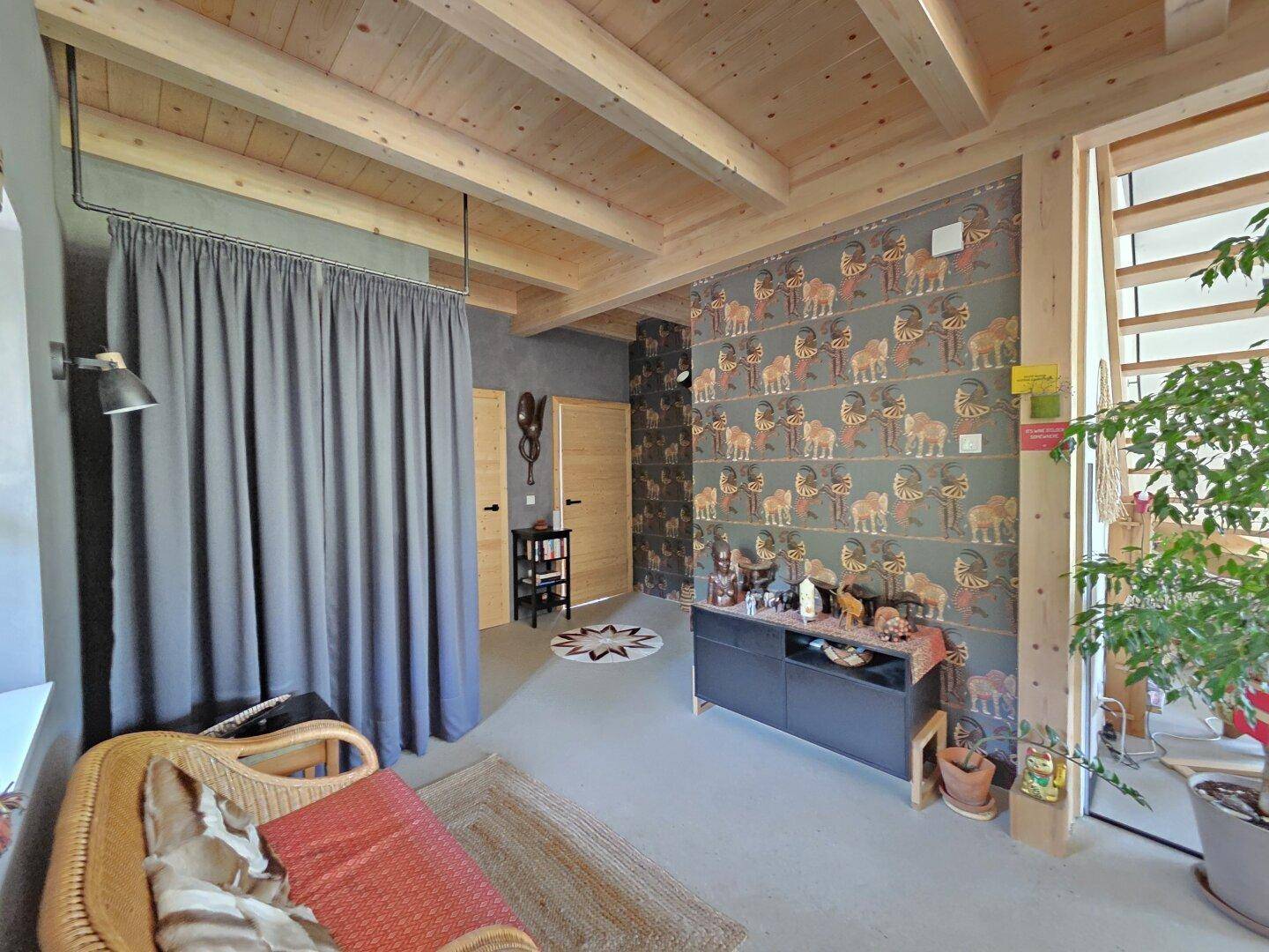 Flur mit Holzbalkendecke, gemusterter Tapete und Zugang zu weiteren Räumen.