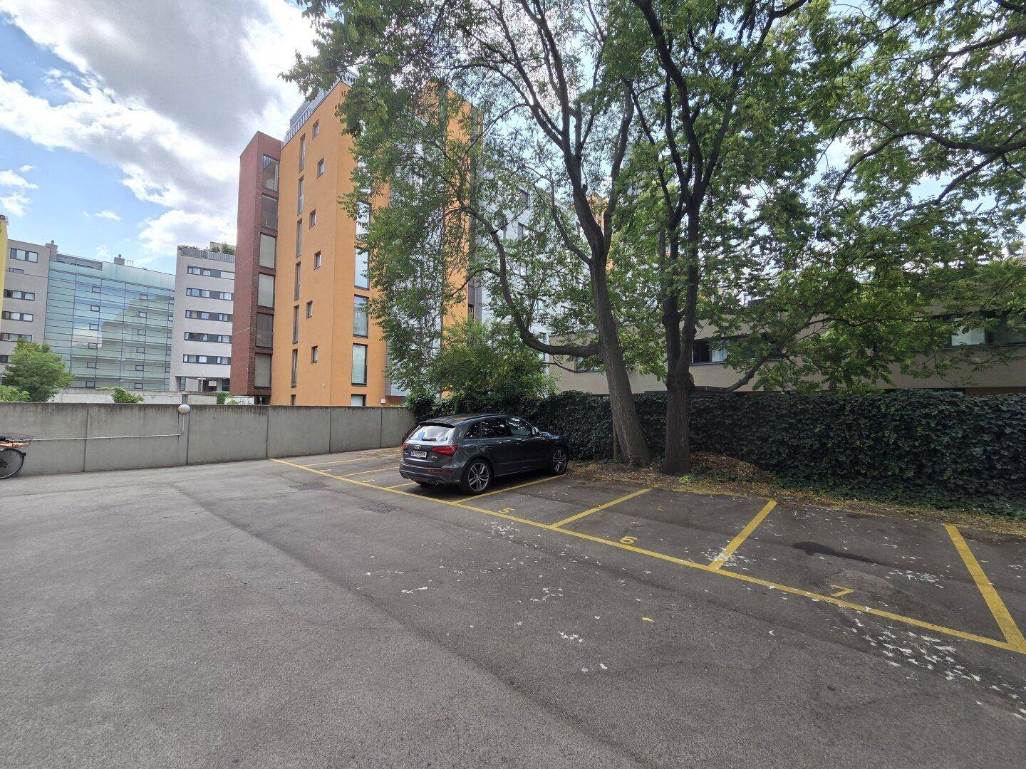 Außenparkplätze mit Bäumen und umliegenden Gebäuden, bietet bequemes Parken.